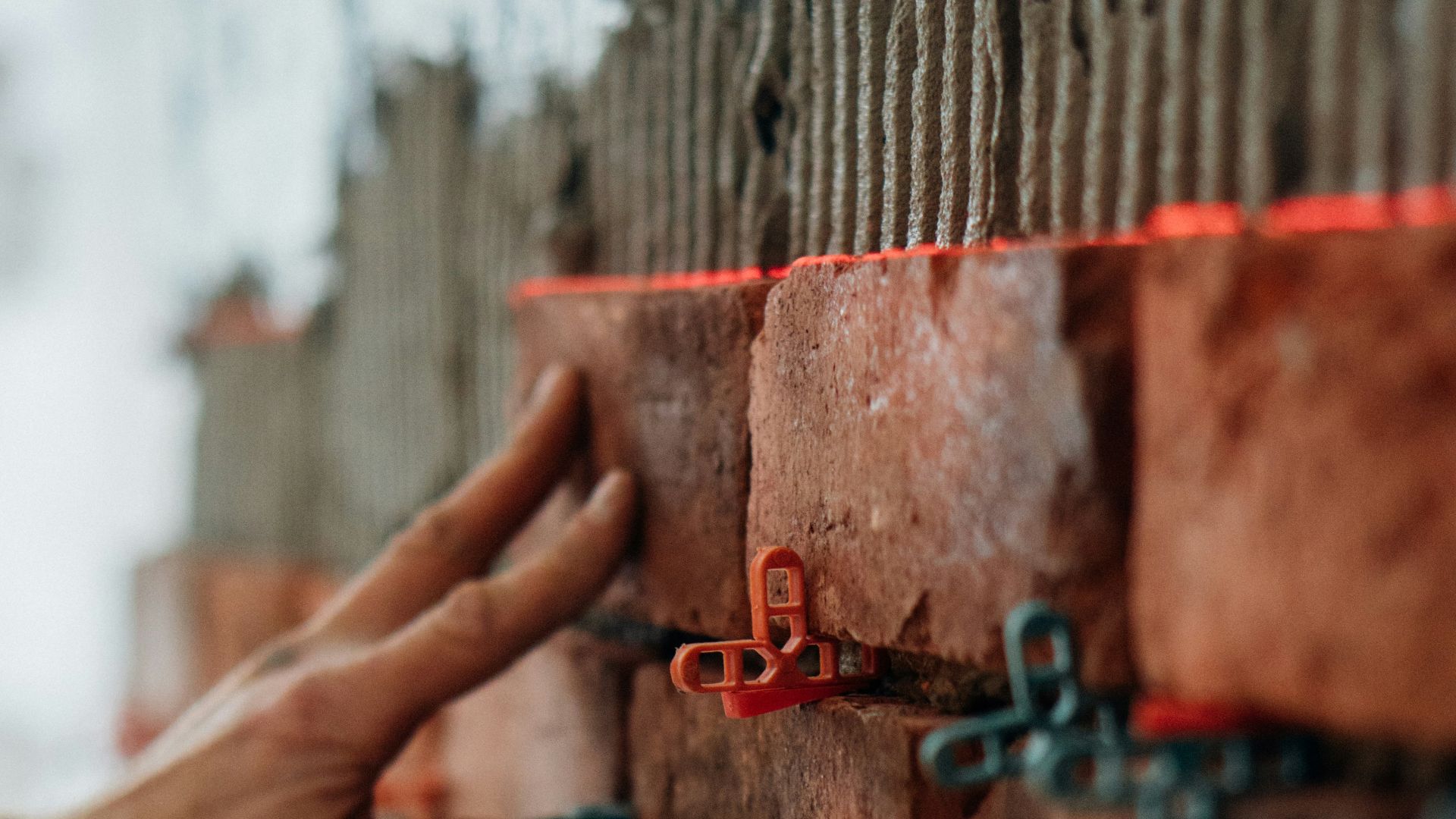 a hand reaching out to a metal fence