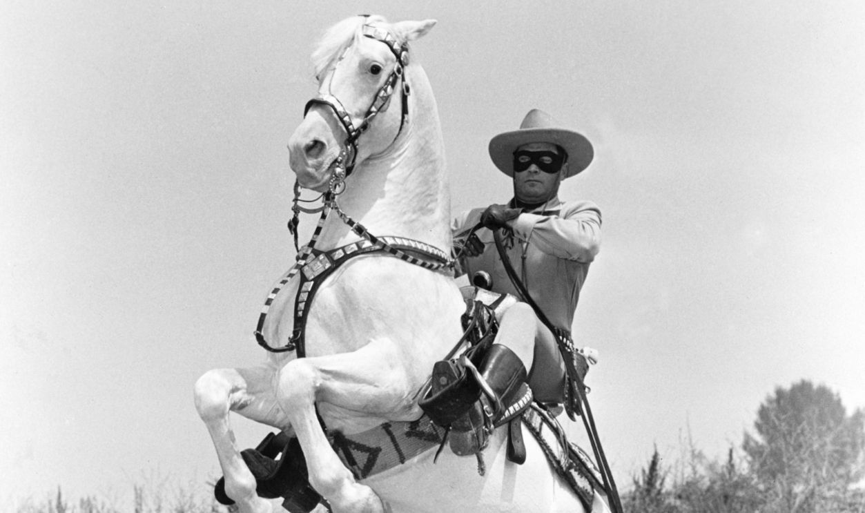 Clayton Moore (1914-1999), US actor, in costume as he sits on his horse, 'Silver', which rears up in a publicity still issued for the television series, 'The Lone Ranger', USA, circa 1950. The adventure series starred Moore as 'The Lone Ranger'.