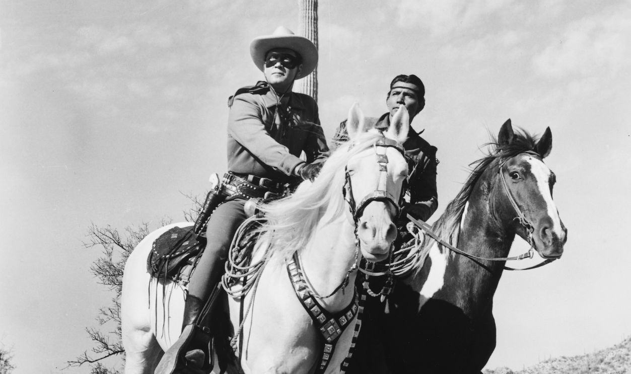 Clayton Moore (1914-1999), US actor, in costume, riding his horse, 'Silver', alongside Jay Silverheels (1912-1980), Canadian Mohawk actor, in costume on his horse, 'Scout', in a publicity still issued for the television series, 'The Lone Ranger', USA, circa 1950. The adventure series starred Moore as 'The Lone Ranger', and Silverheels as 'Tonto'.