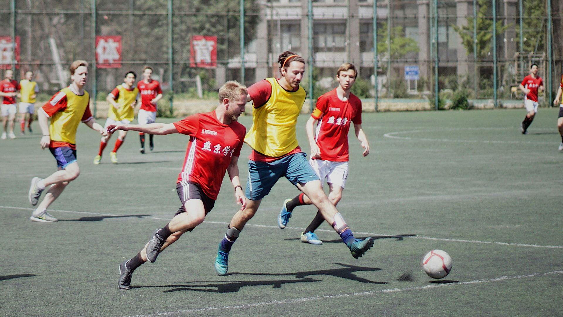men playing soccer on field with fence