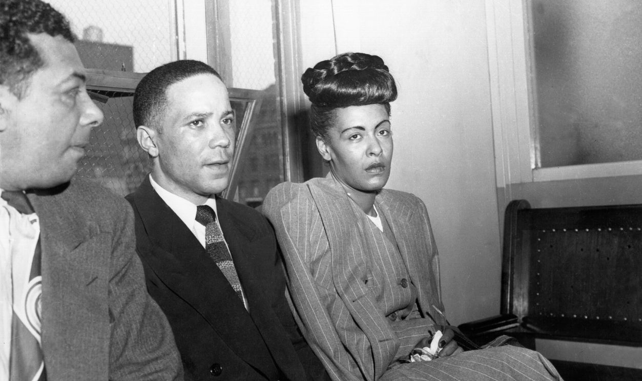 Jazz singer Billie Holiday (R) is read the charge for heroin possession at the U.S. Commissioners Office, seated next to her are her pianist Bobby Tucker (C) and road manager James Asendio (R) on May, 20, 1947 in Philadelphia, Pennsylvania.