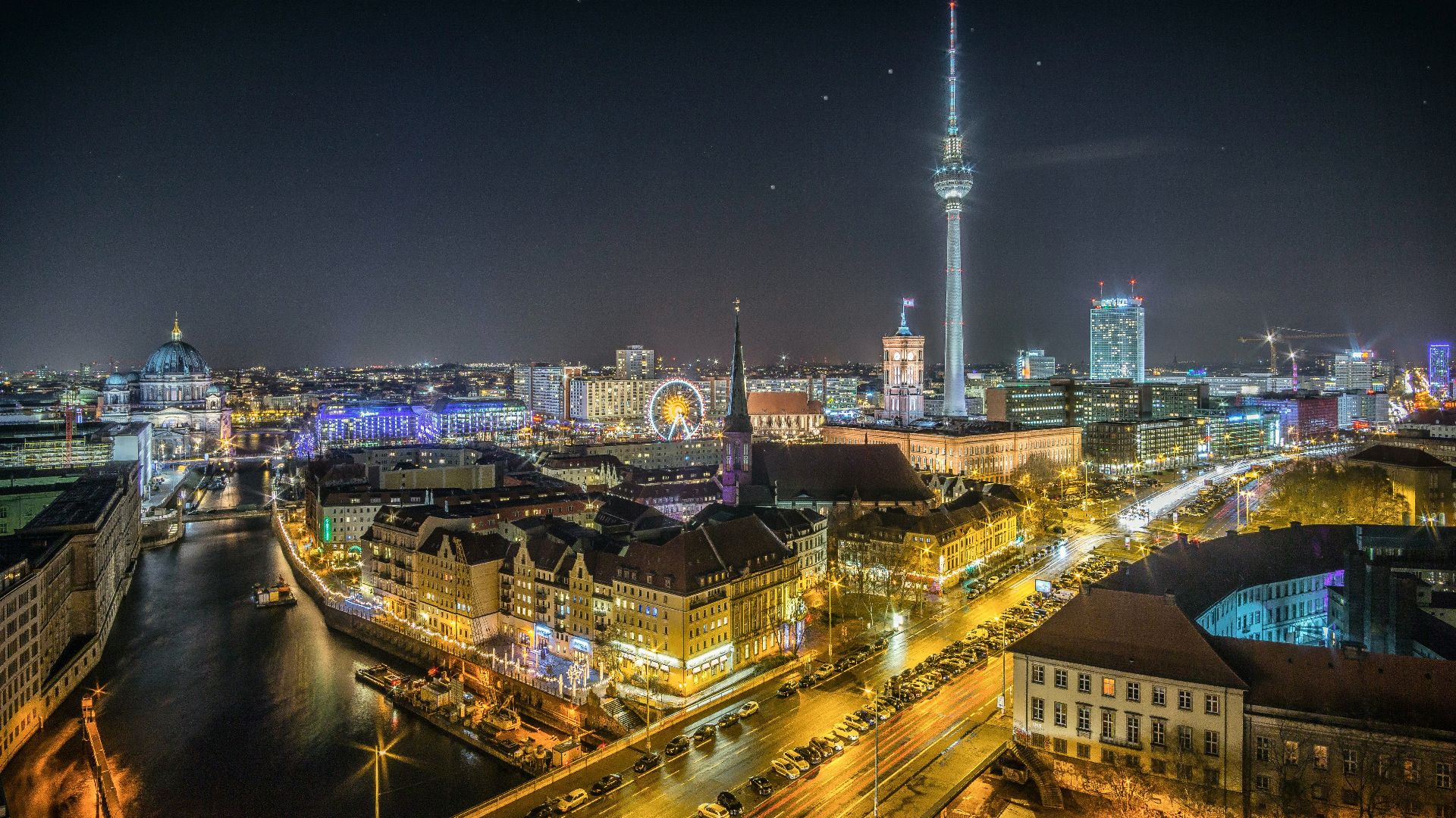 time-lapse photography of vehicle at the road in between the building at nighttime aerial photography