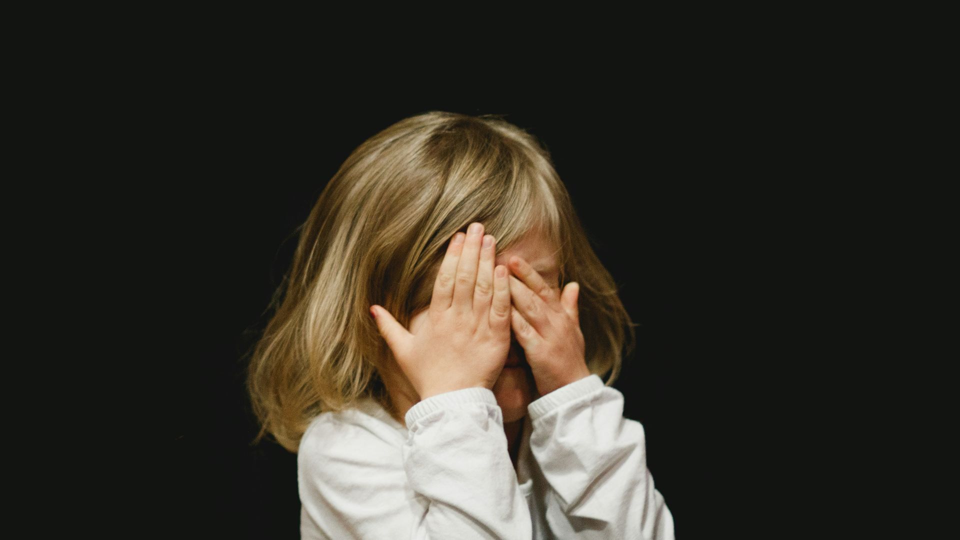 girl covering her face with both hands