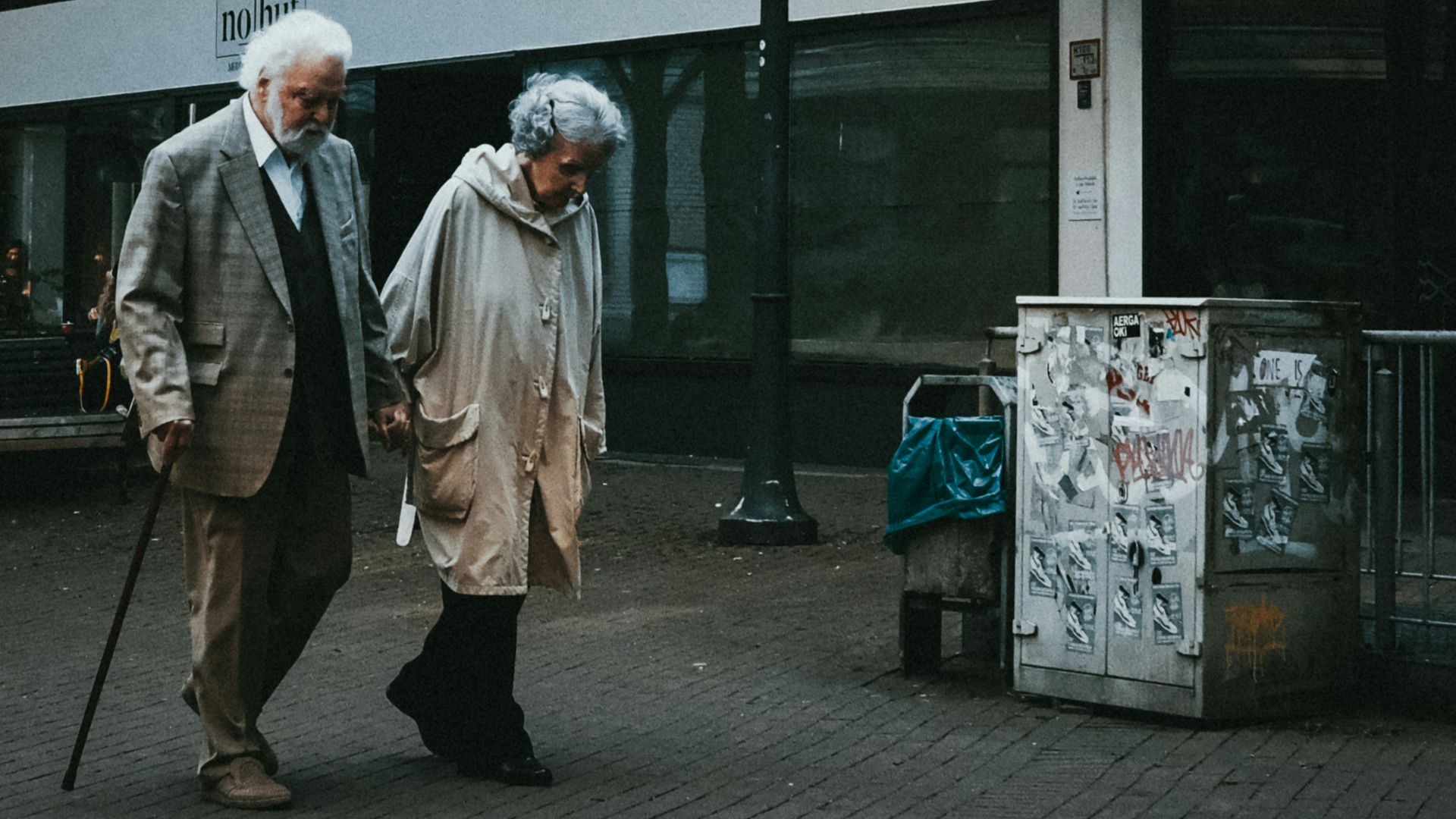 man in black suit standing beside woman in white coat