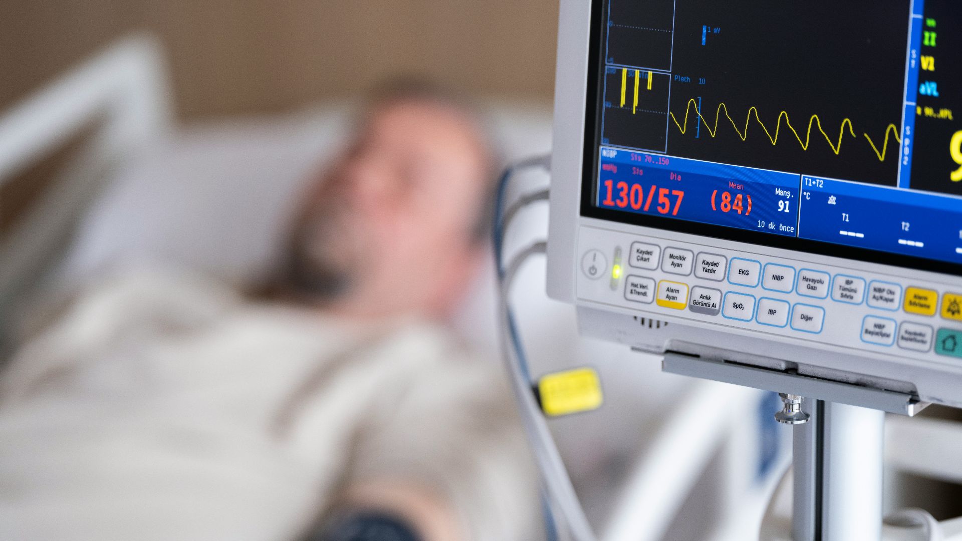 a man laying in a hospital bed next to a monitor