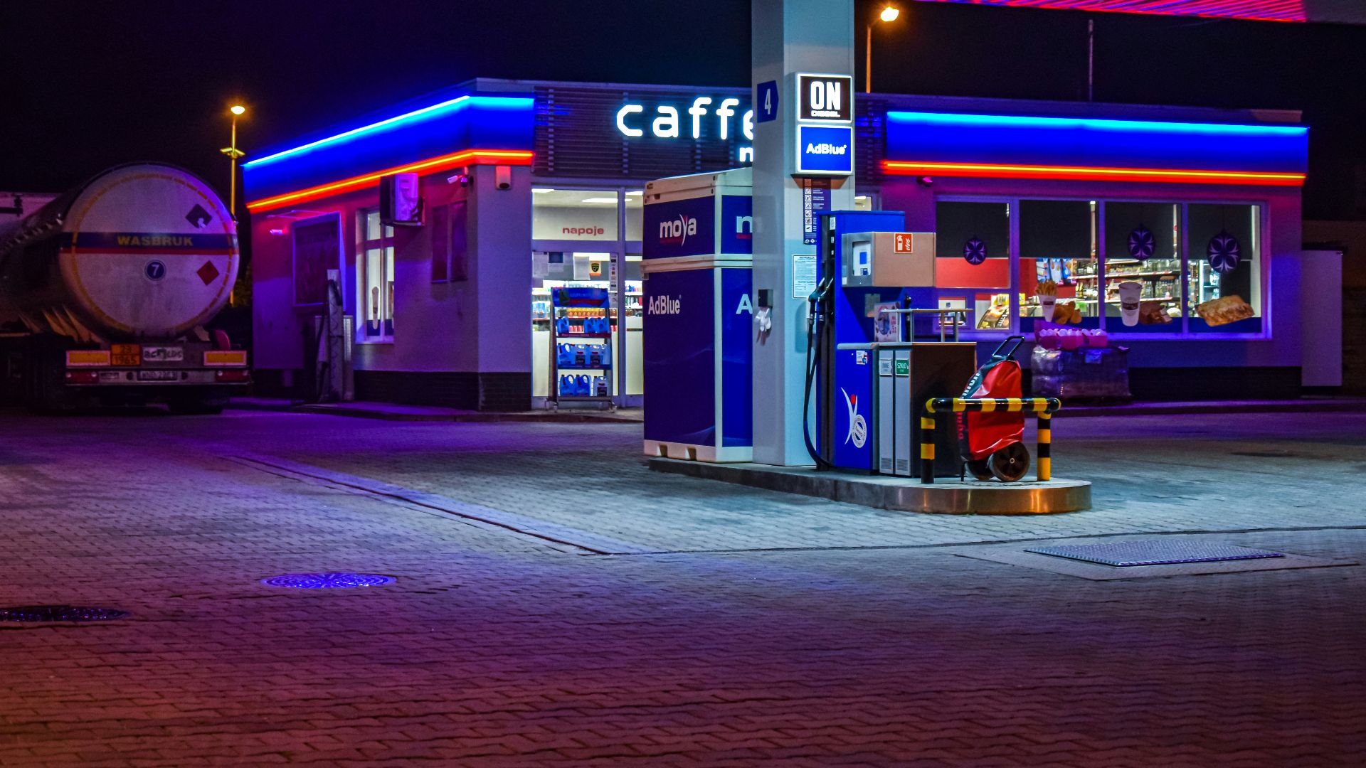 a gas station lit up at night with neon lights
