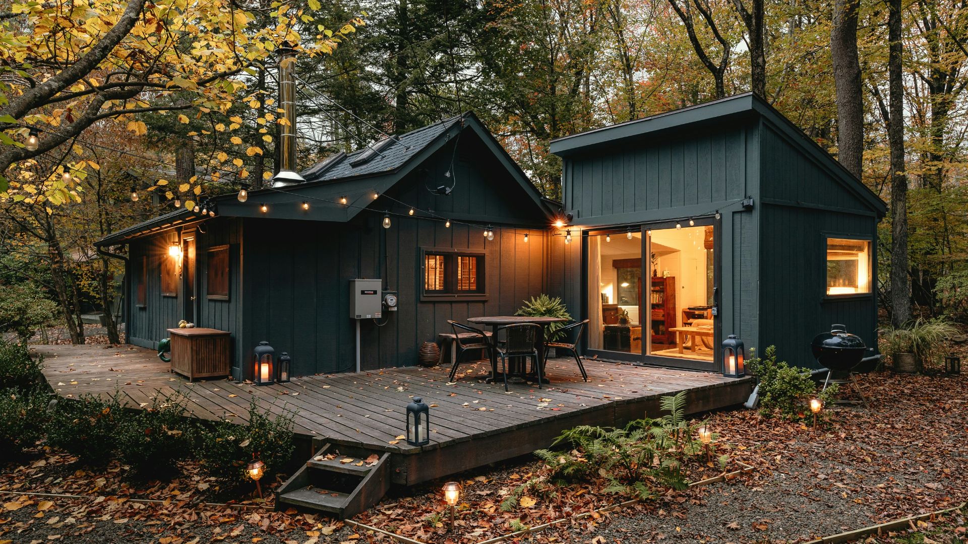 a small cabin with a deck in the woods