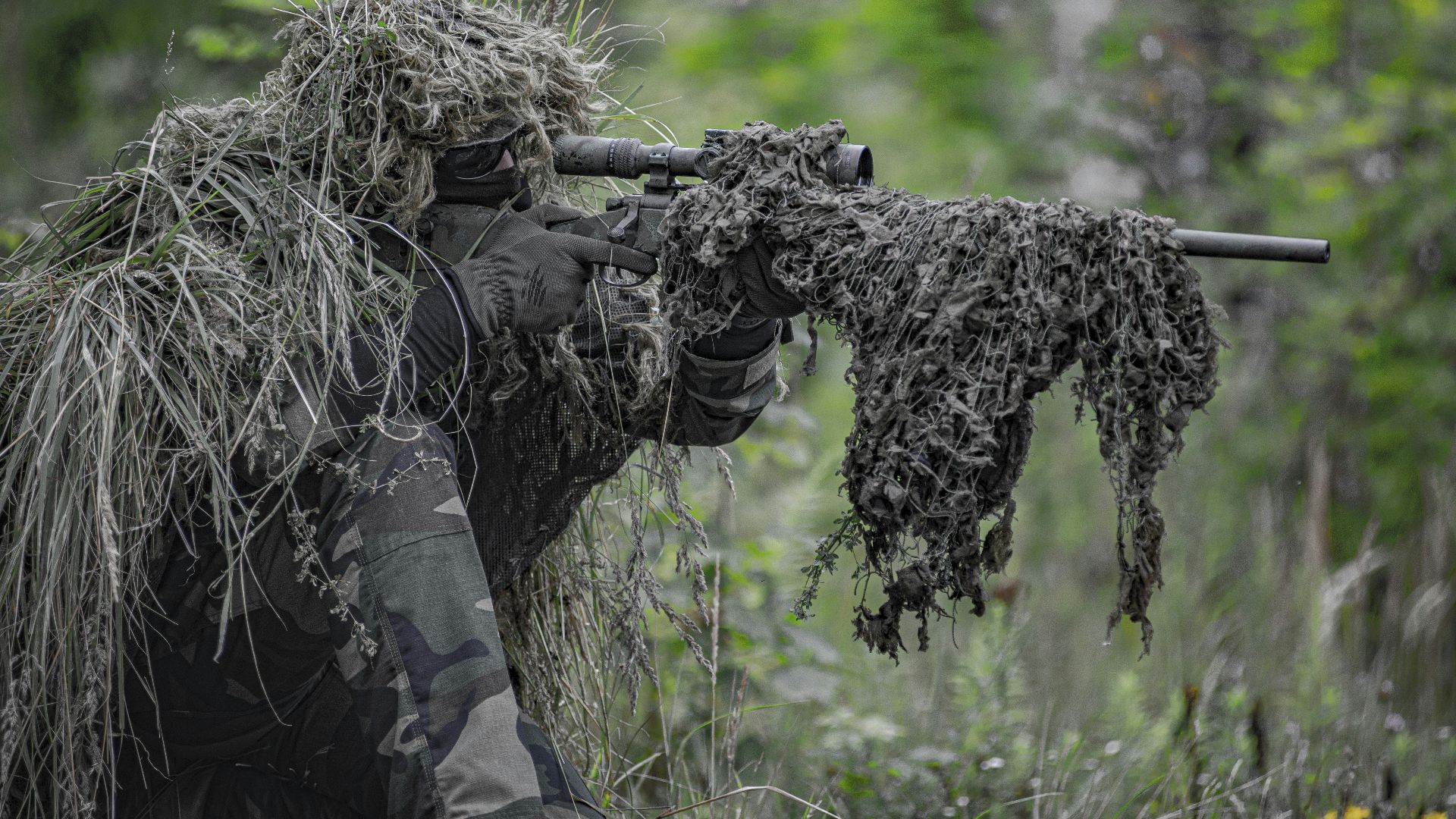 sniper wearing a ghillie in selective focus photography