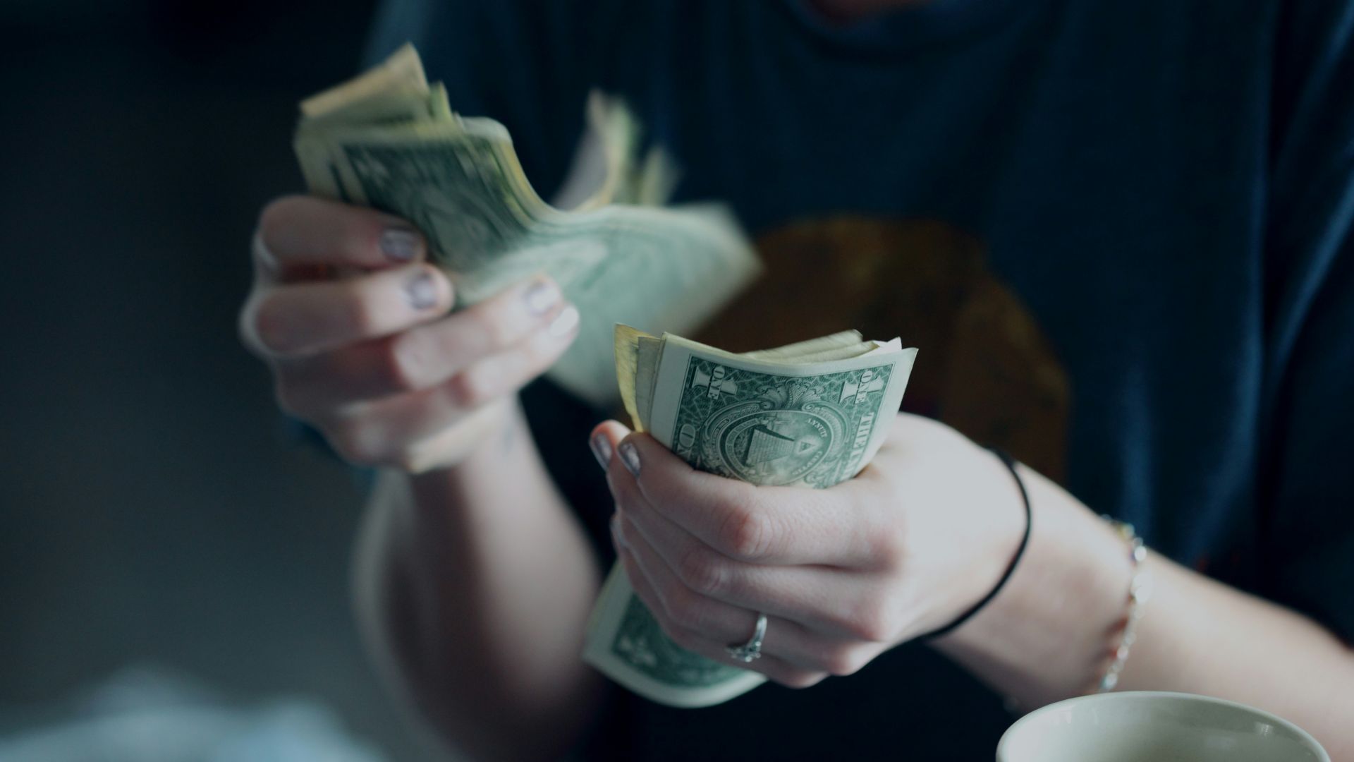focus photography of person counting dollar banknotes