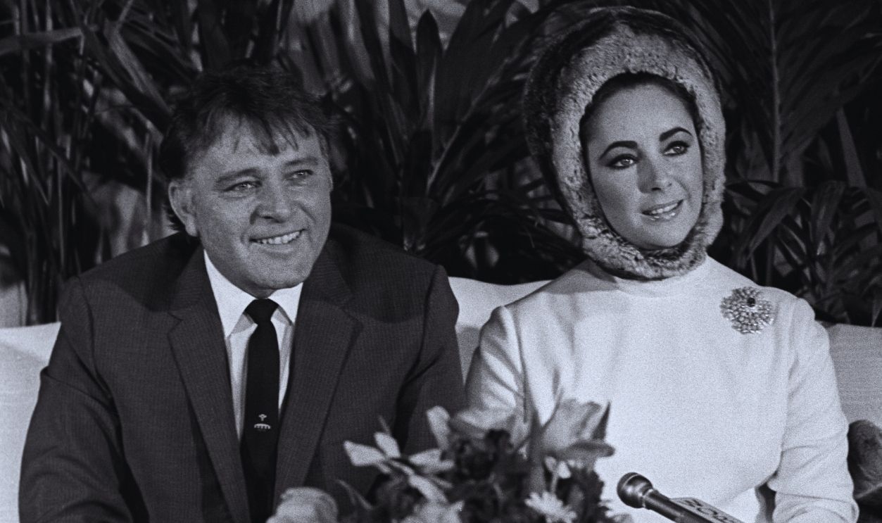 Gettyimages - 1460935468, Taylor-Burton Press Conference, New York Elizabeth Taylor wearing a fur hat at a press conference with husband Richard Burton 