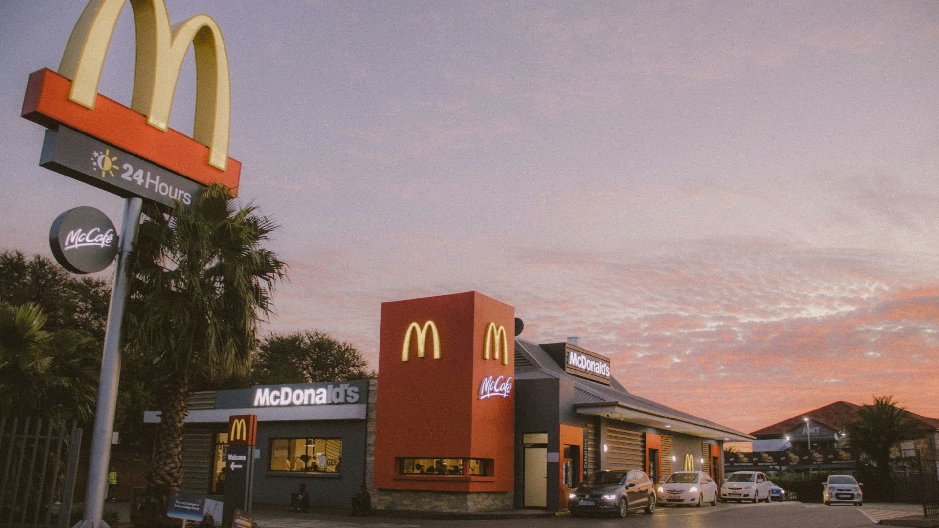 red and white concrete building near palm trees during daytime