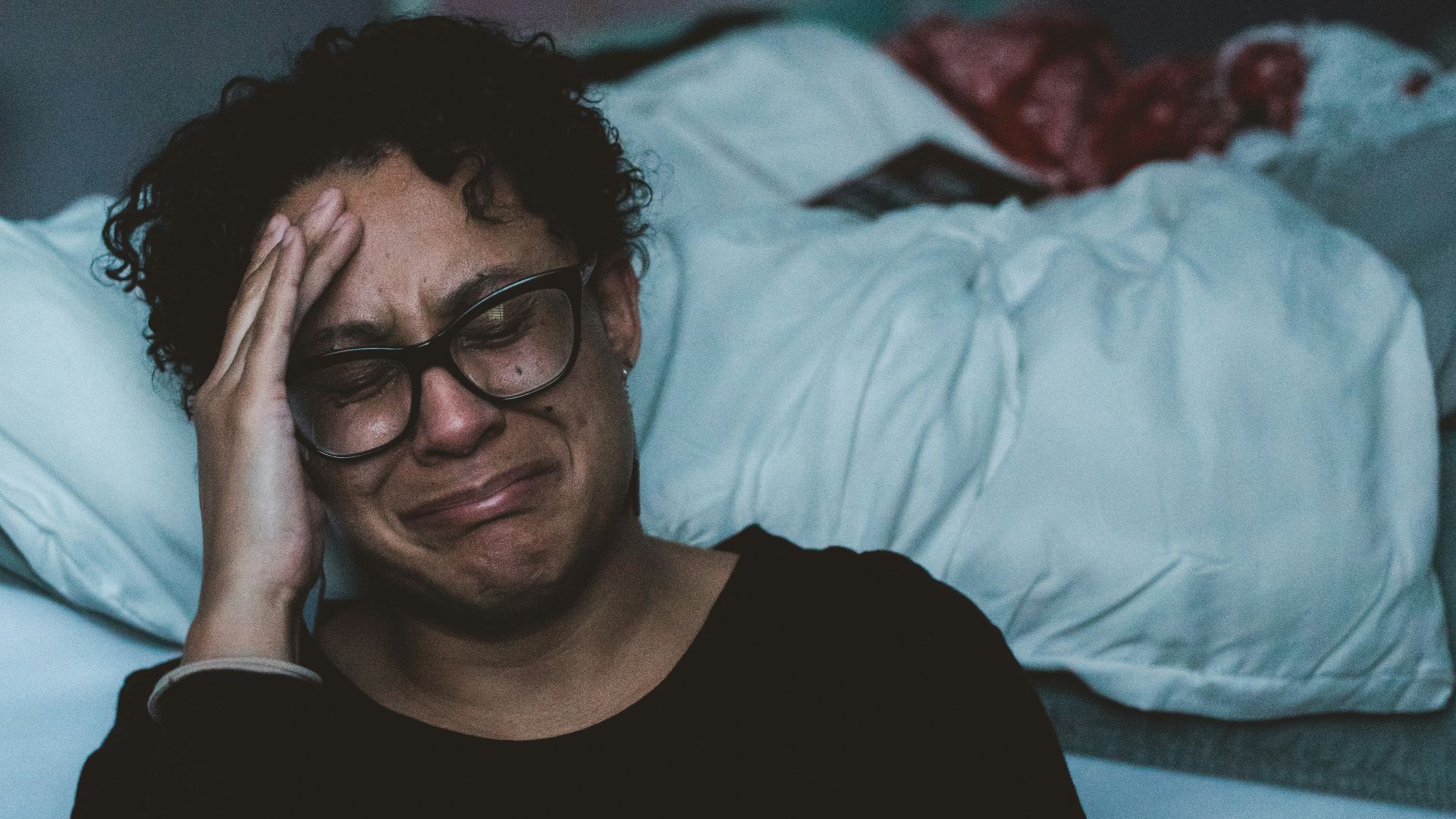 person crying beside bed