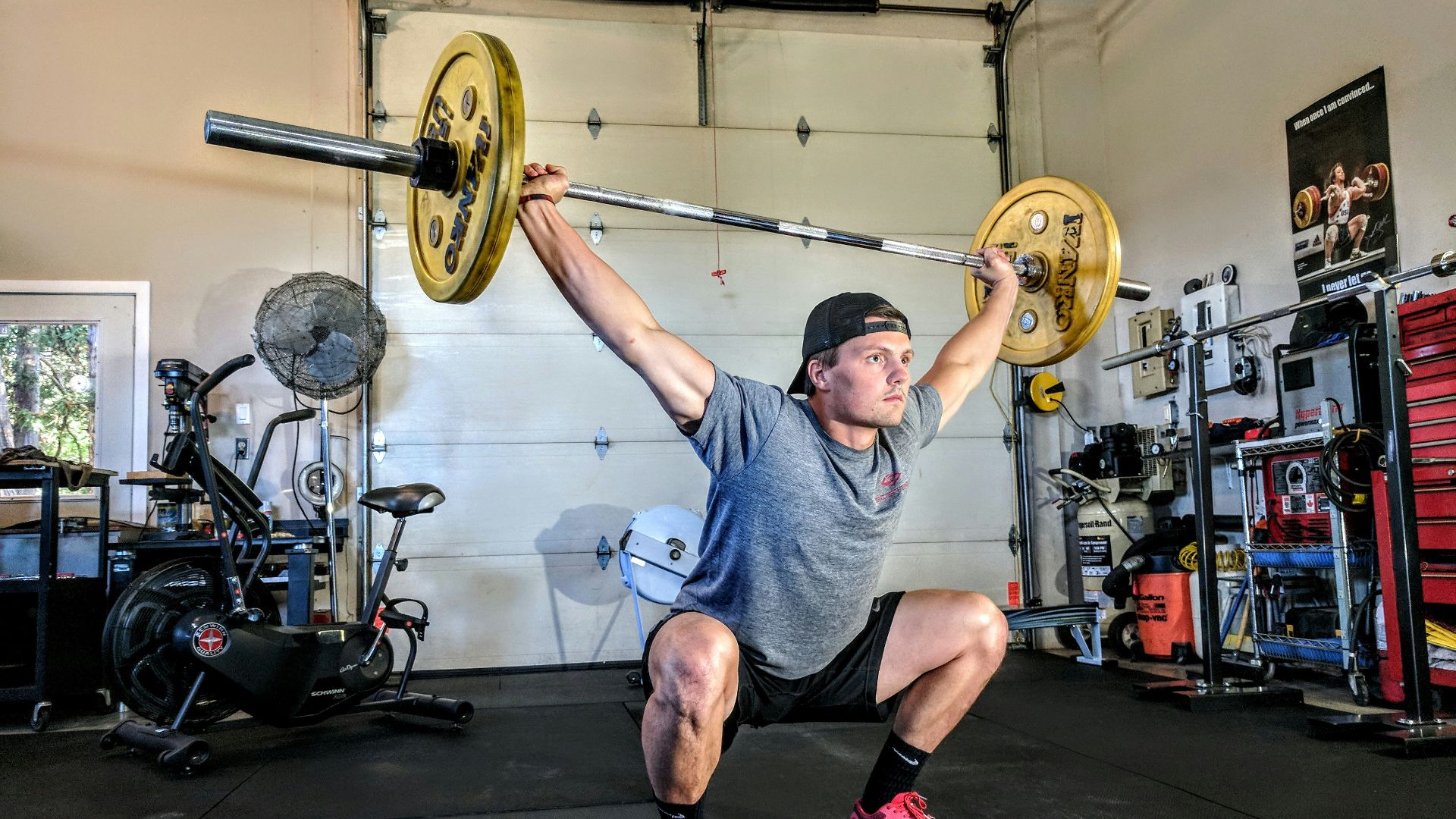 man lifting yellow barbell