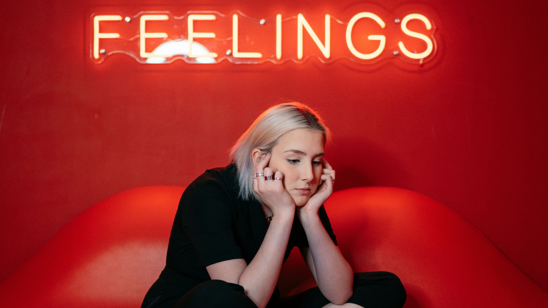 woman in black long sleeve shirt and black pants sitting on red couch