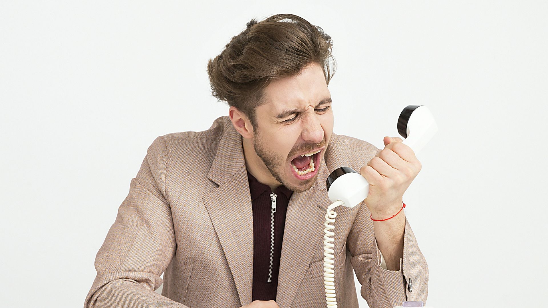 man holding telephone screaming