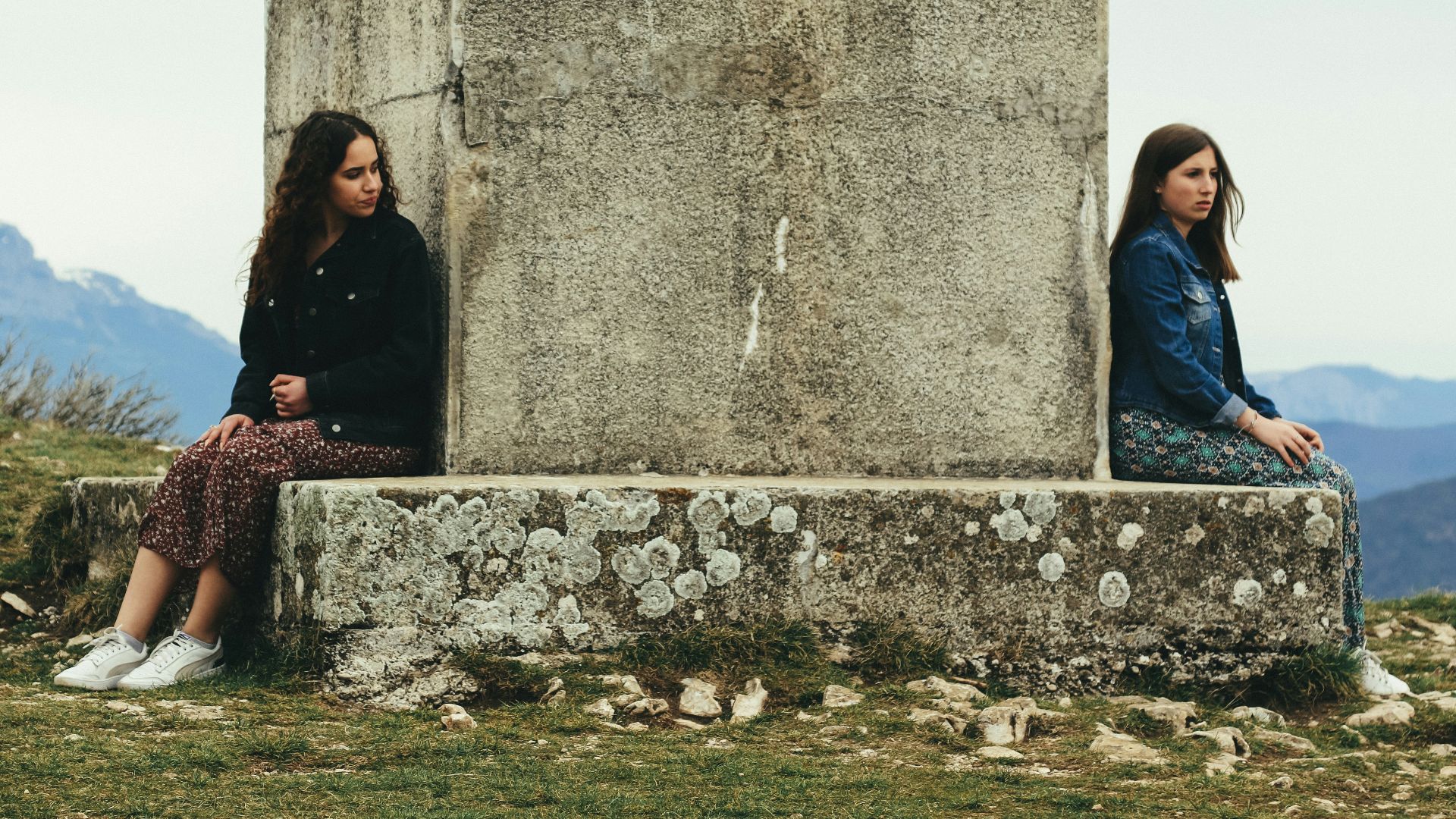 woman in black jacket sitting beside woman in black jacket