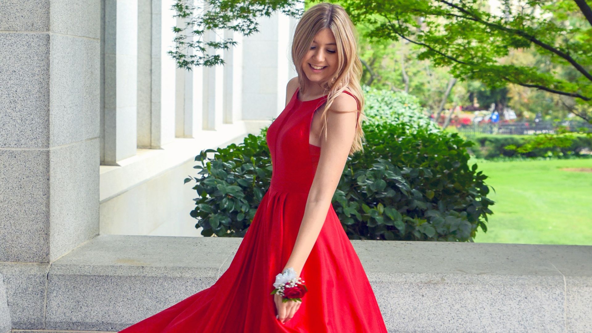 woman in red sleeveless dress standing on gray concrete floor during daytime