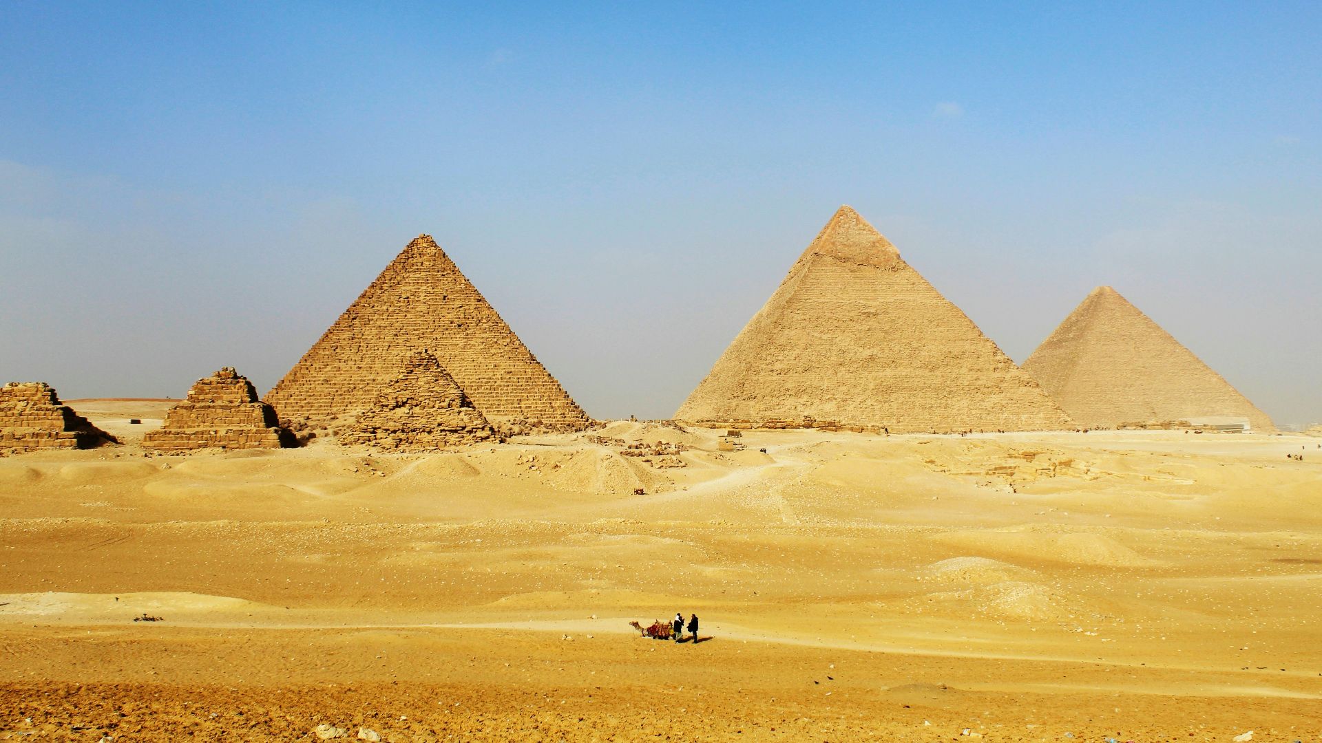a group of pyramids in the desert with a sky background