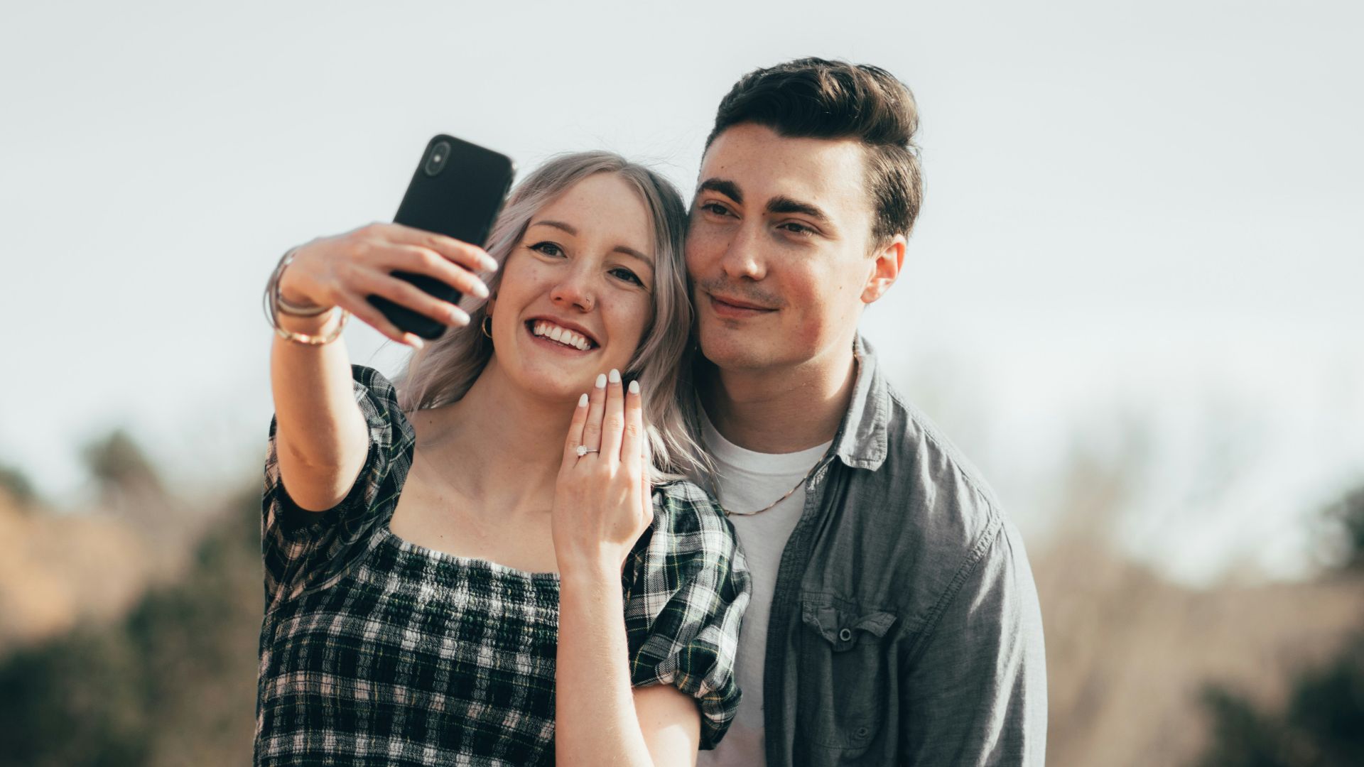 a man taking a picture of a woman with a cell phone