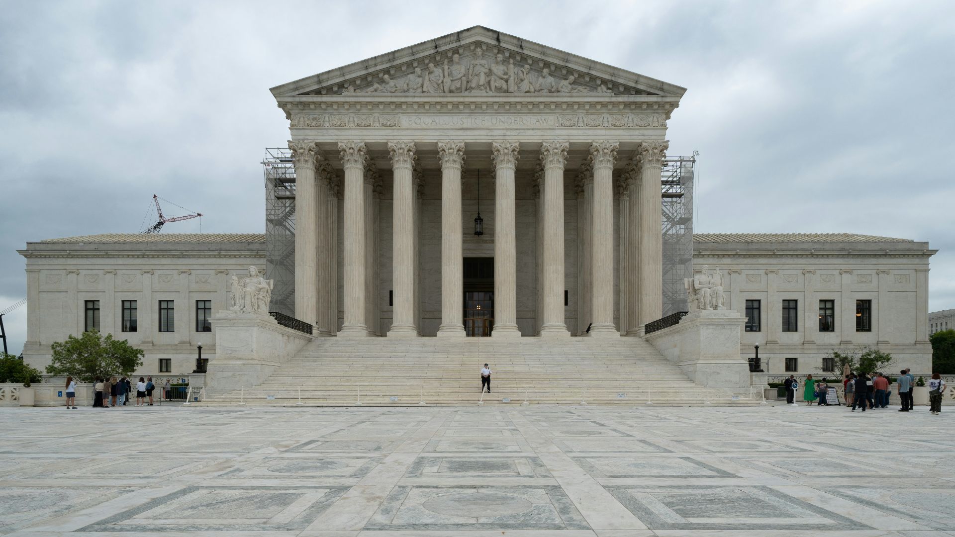 A large building with columns and pillars on a cloudy day