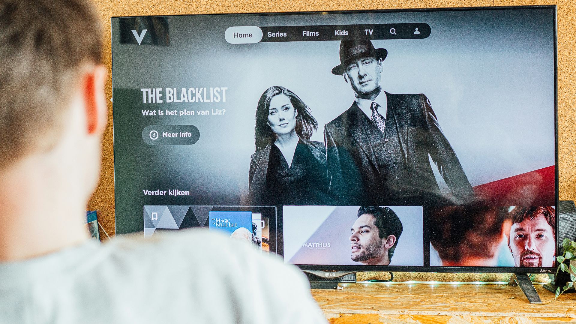 a man looking at a television screen with the show the blacklist on it