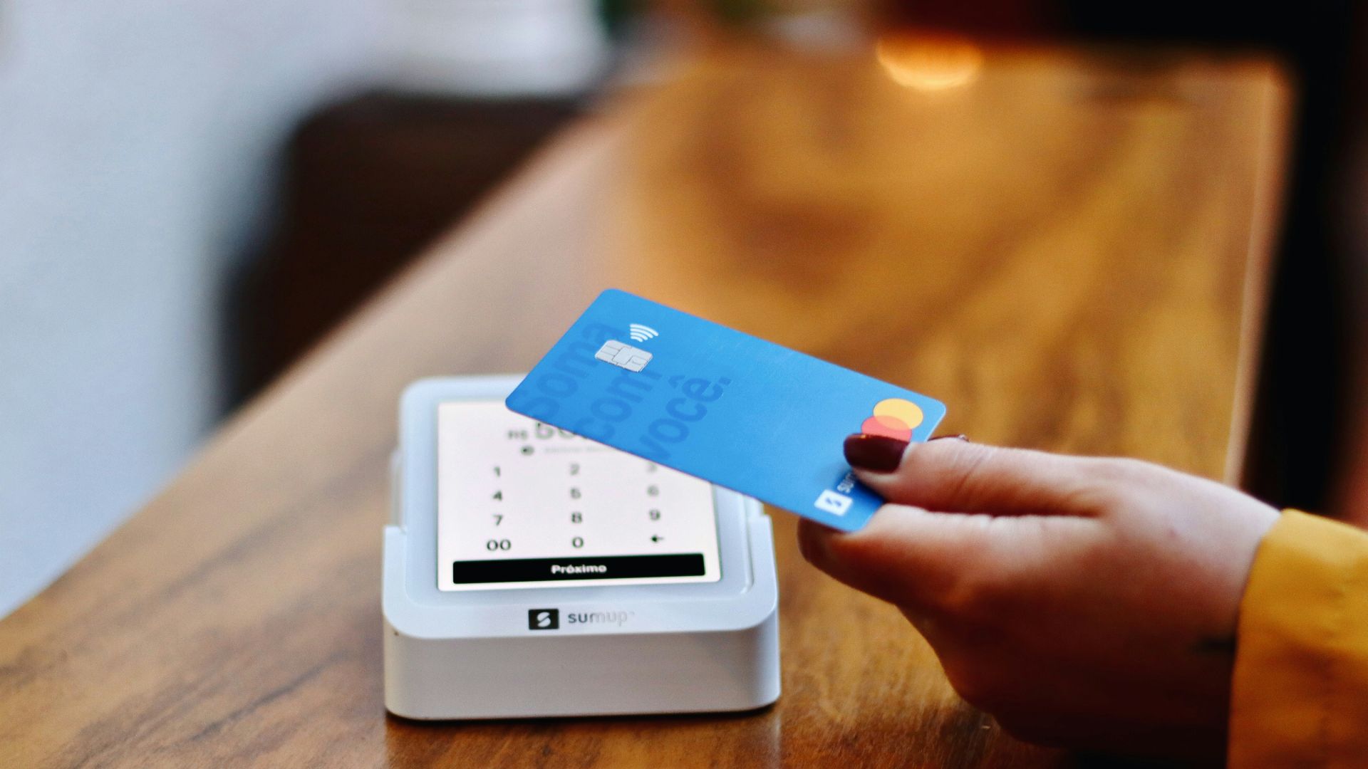 a person holding a credit card in front of a machine