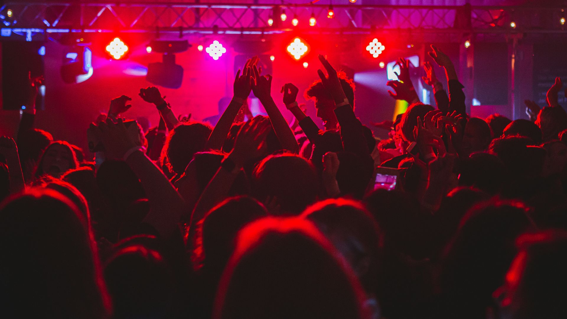 people standing on stage with lights turned on during nighttime