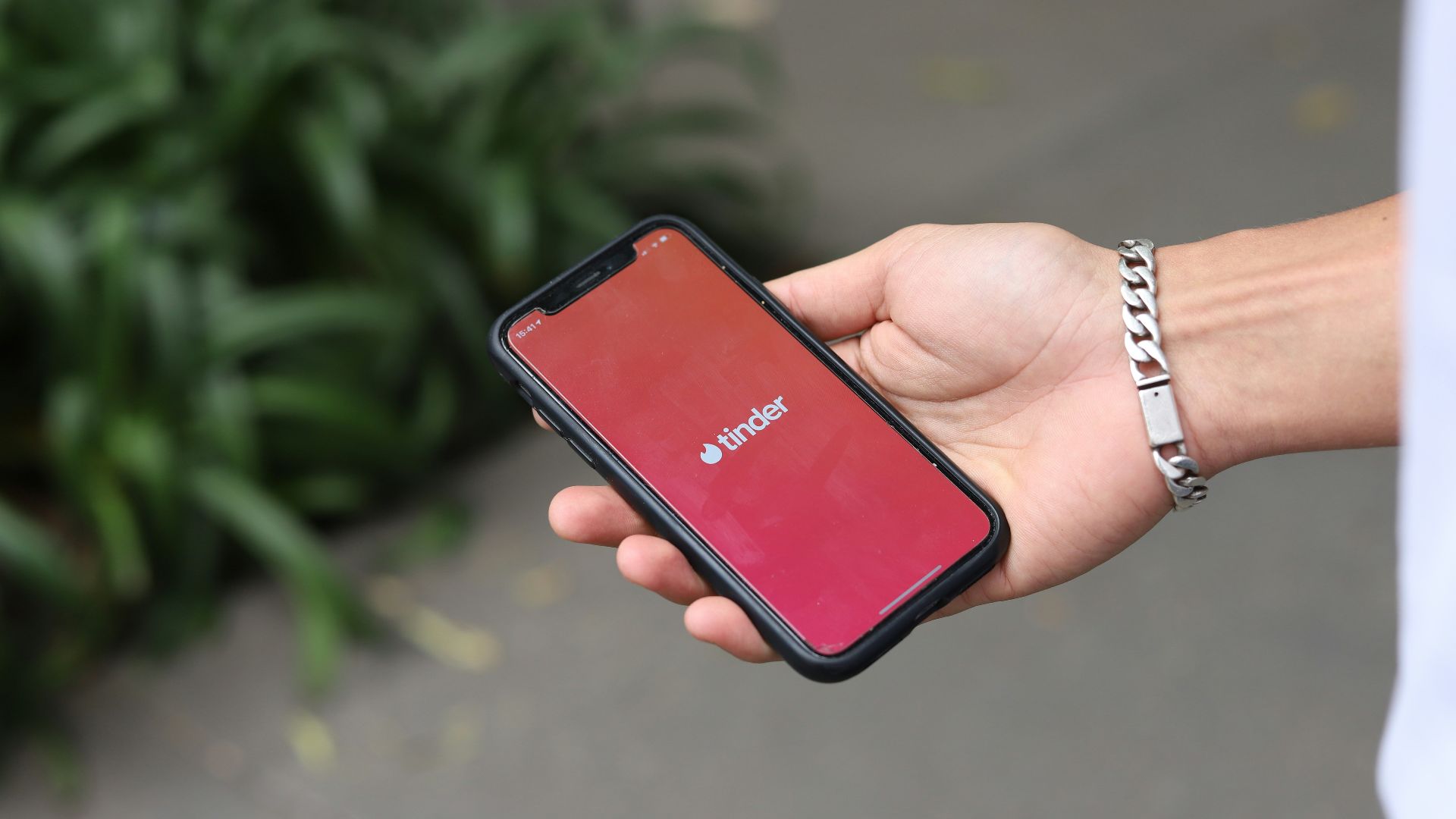 a person holding a red cell phone in their hand
