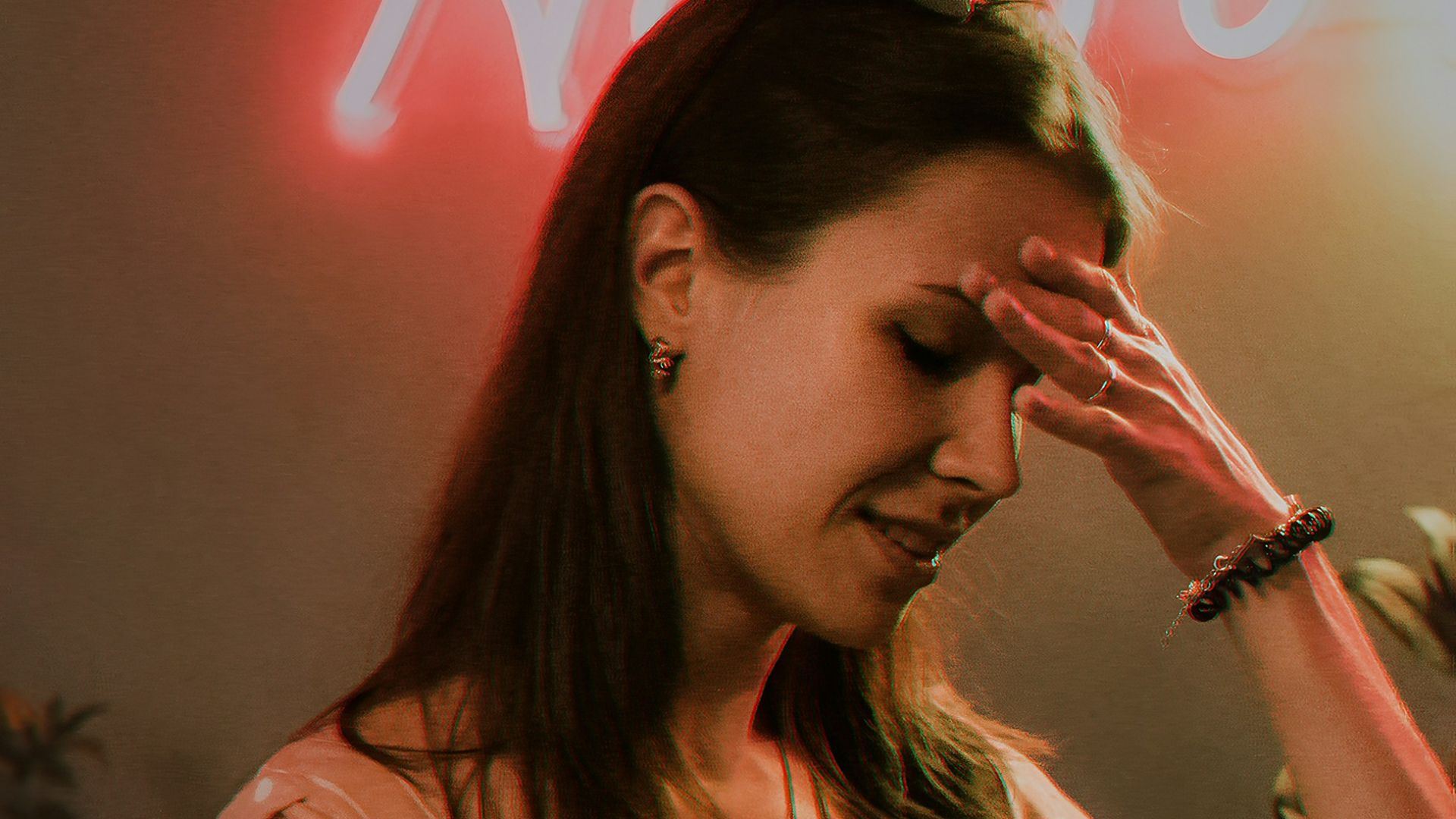 a woman standing in front of a neon sign