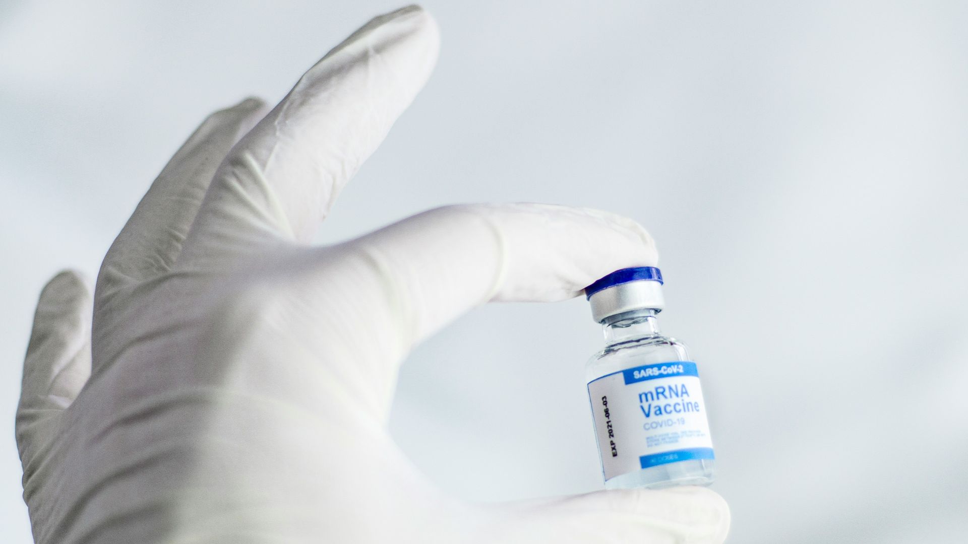 person holding white and orange plastic bottle