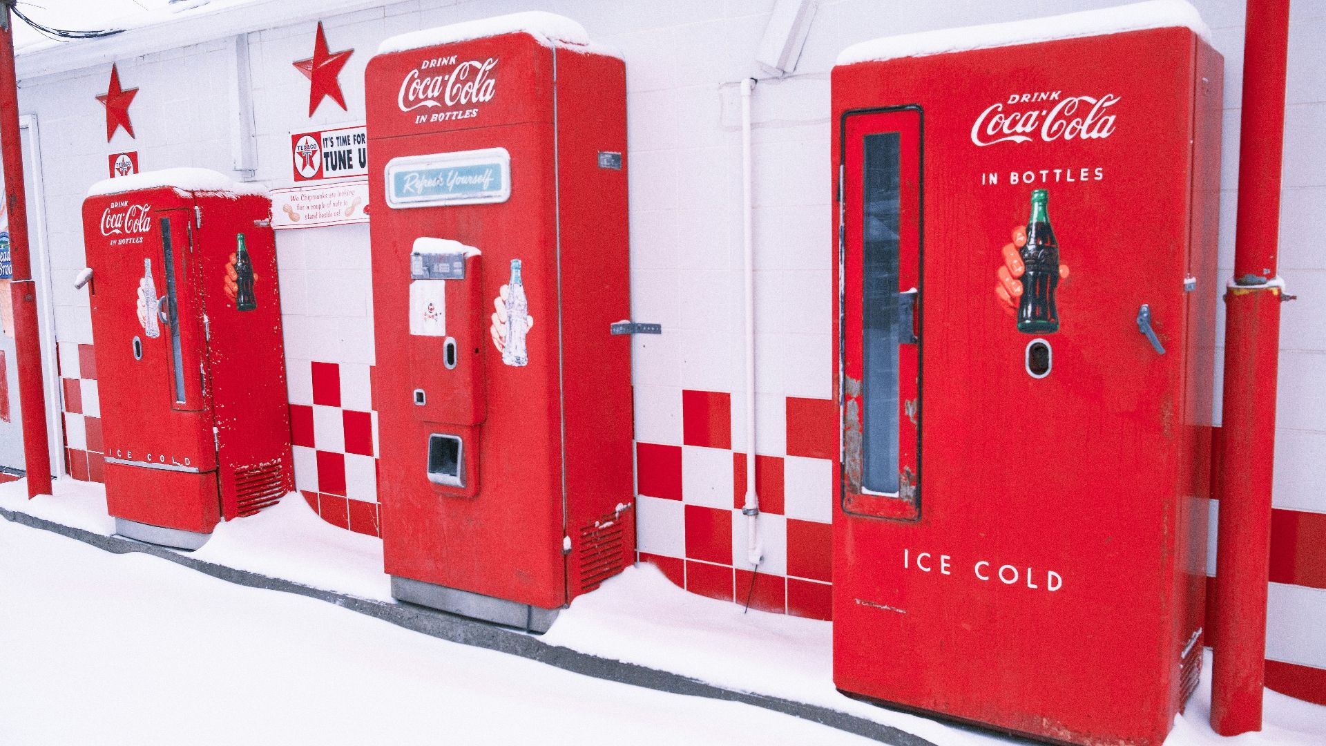 Vintage coca-cola vending machines in the snow.