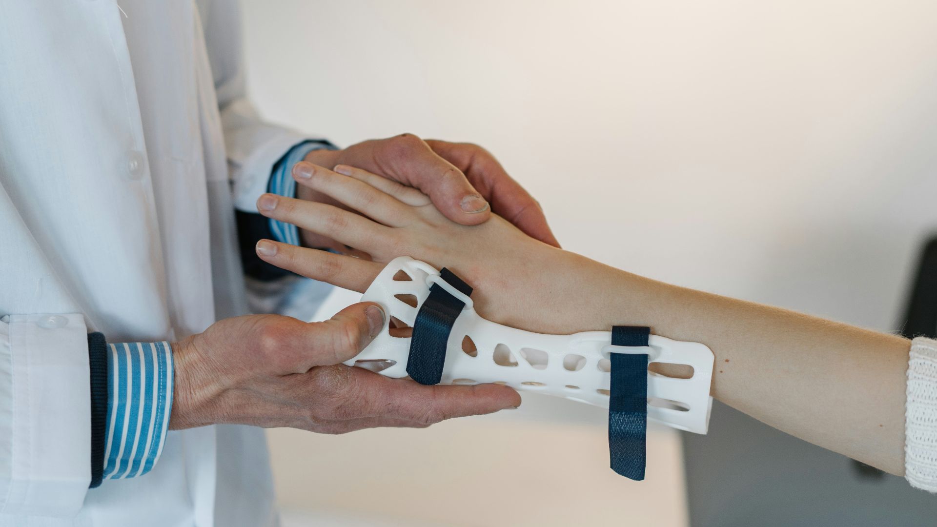 person in white coat holding silver and blue ring