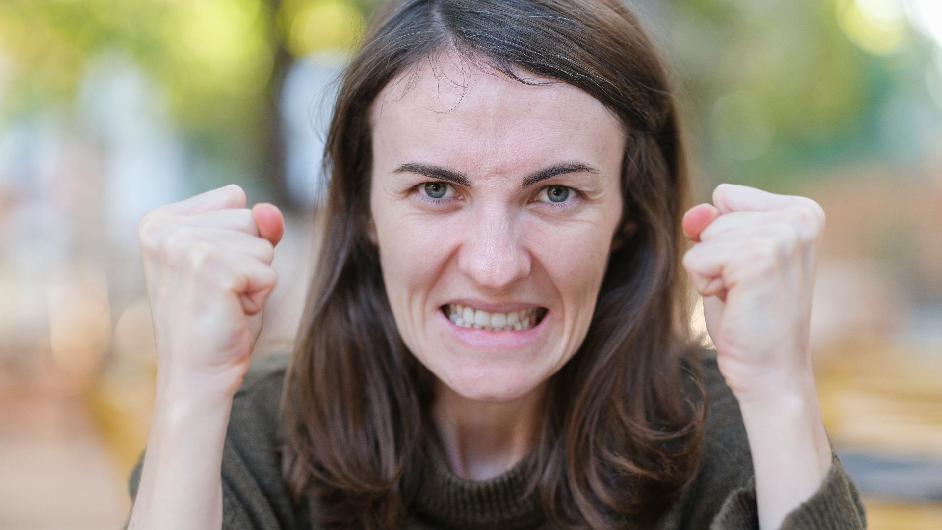 a woman holding her fists up in the air