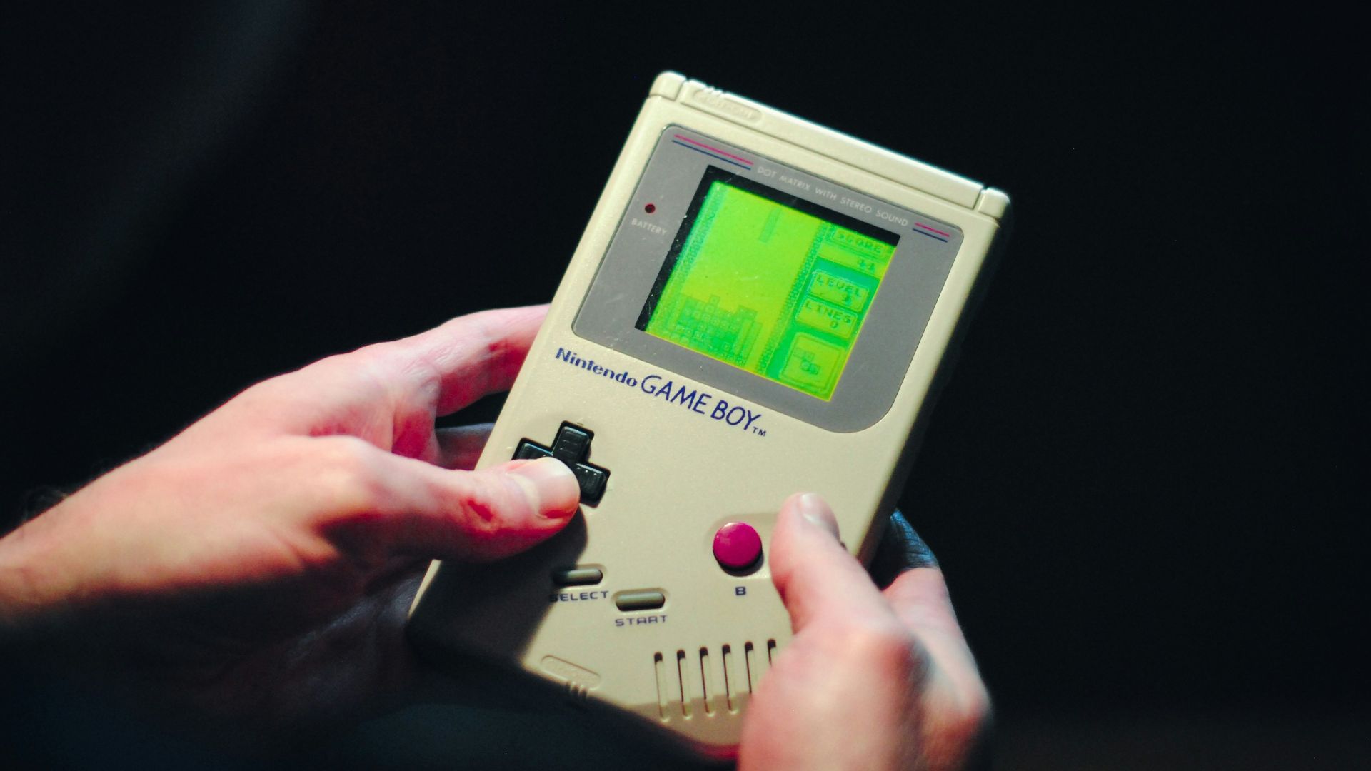 person holding gray nintendo game boy
