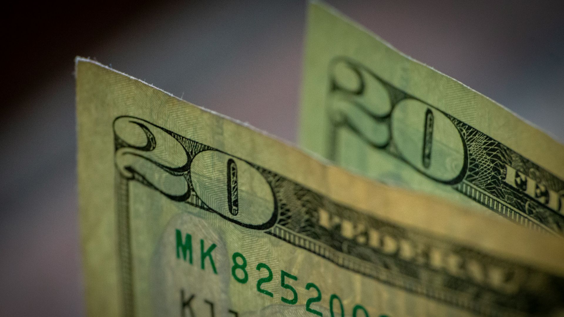 two stacks of twenty dollar bills sitting on top of each other