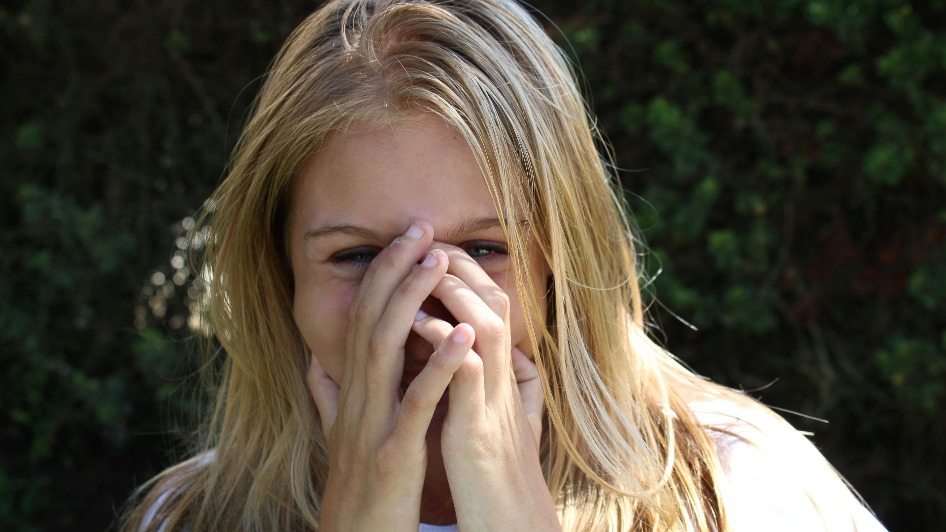 woman covering face with both hands