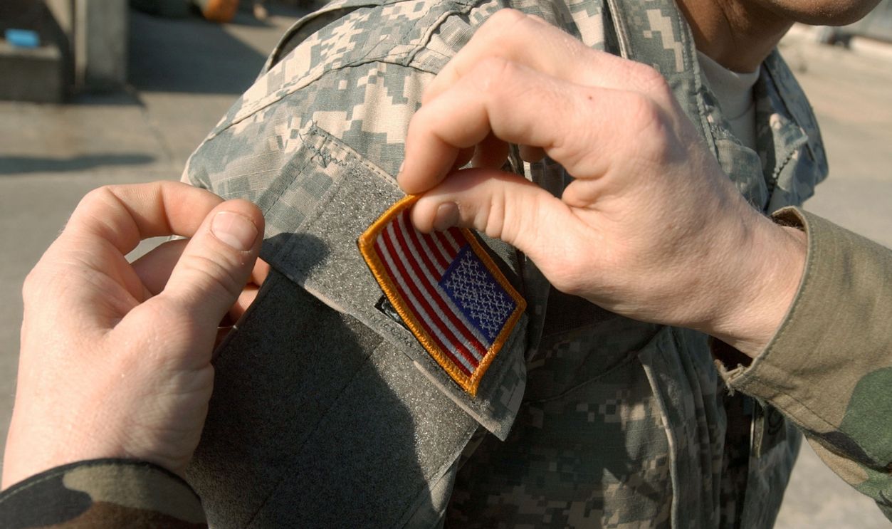 Army soldier with the Georgia National Guard's 48th Infantry Brigade has U.S. flag applied with Velcro to his newly issued Army Combat Uniform (ACU) February 8, 2005 at Fort Stewart, Georgia. The ACU includes a new universal camouflage pattern and provides moisture wicking, functionality and ergonomics.