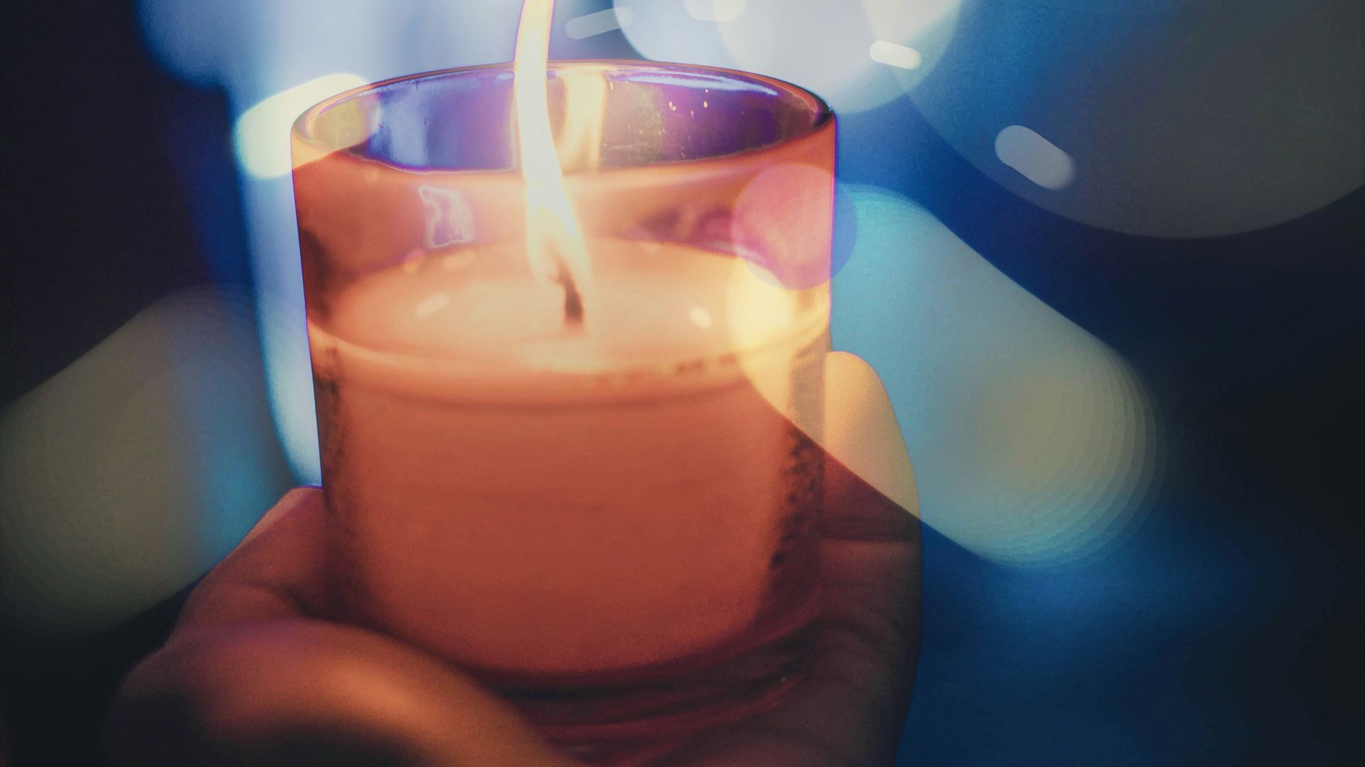 person holding lighted votive candle