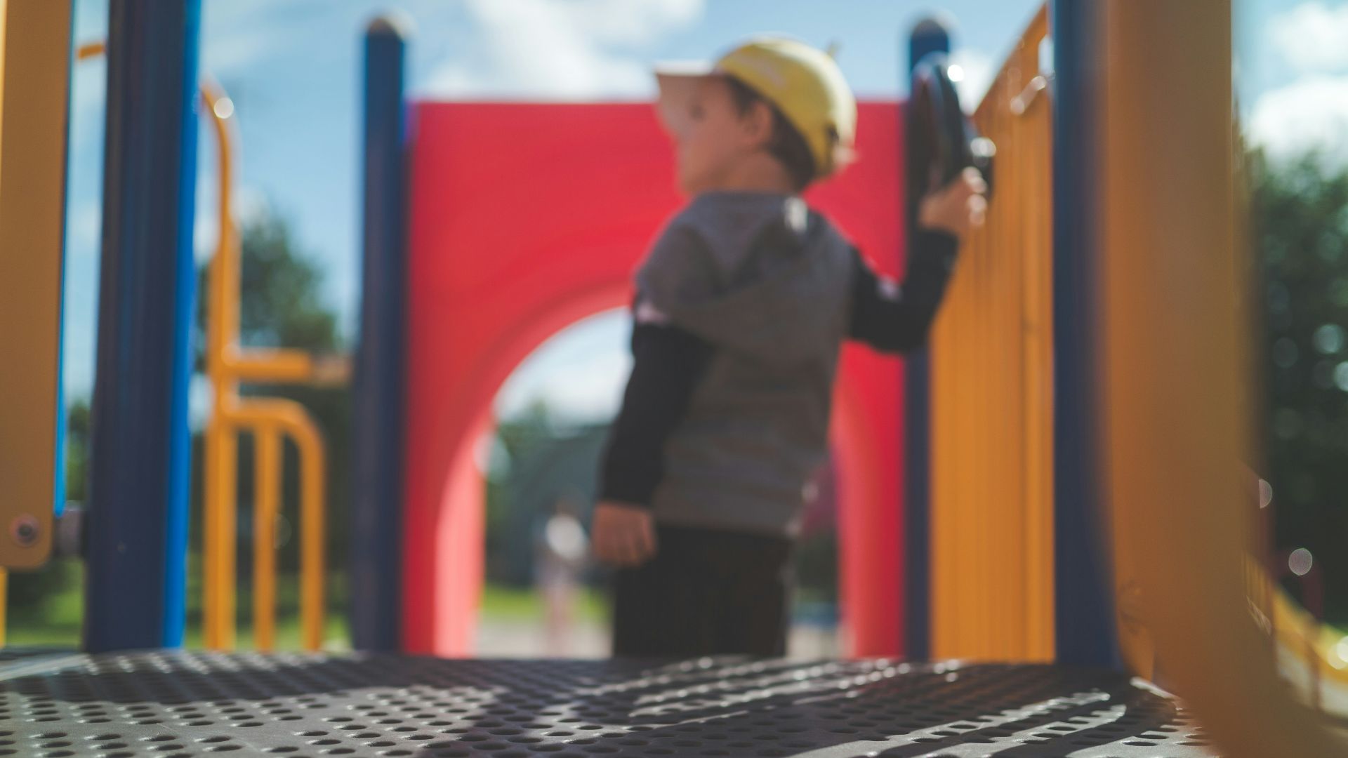 man in black vest and black pants standing beside red and yellow wall