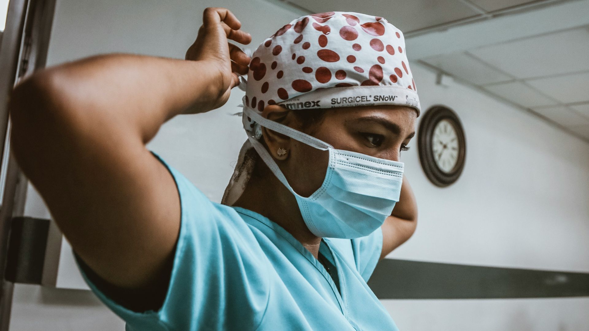woman in teal shirt wearing white mask