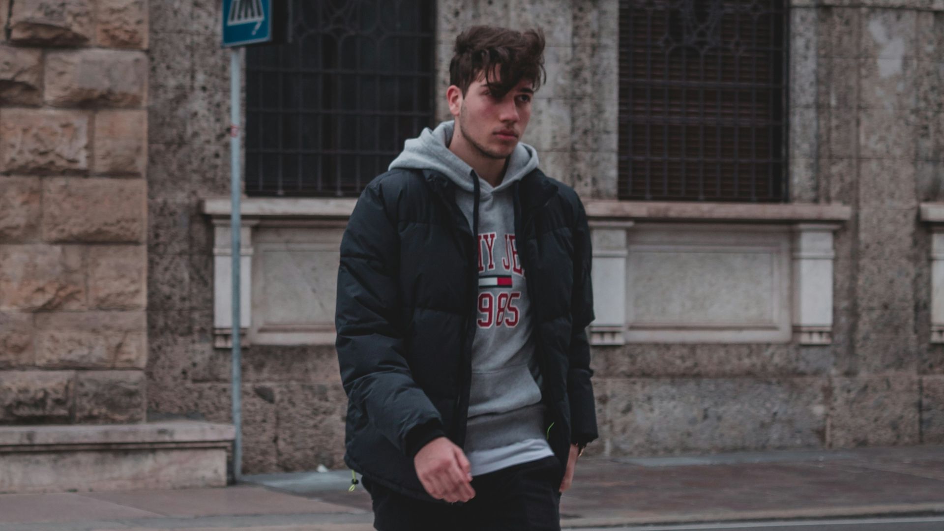 man in black jacket standing on pedestrian lane during daytime
