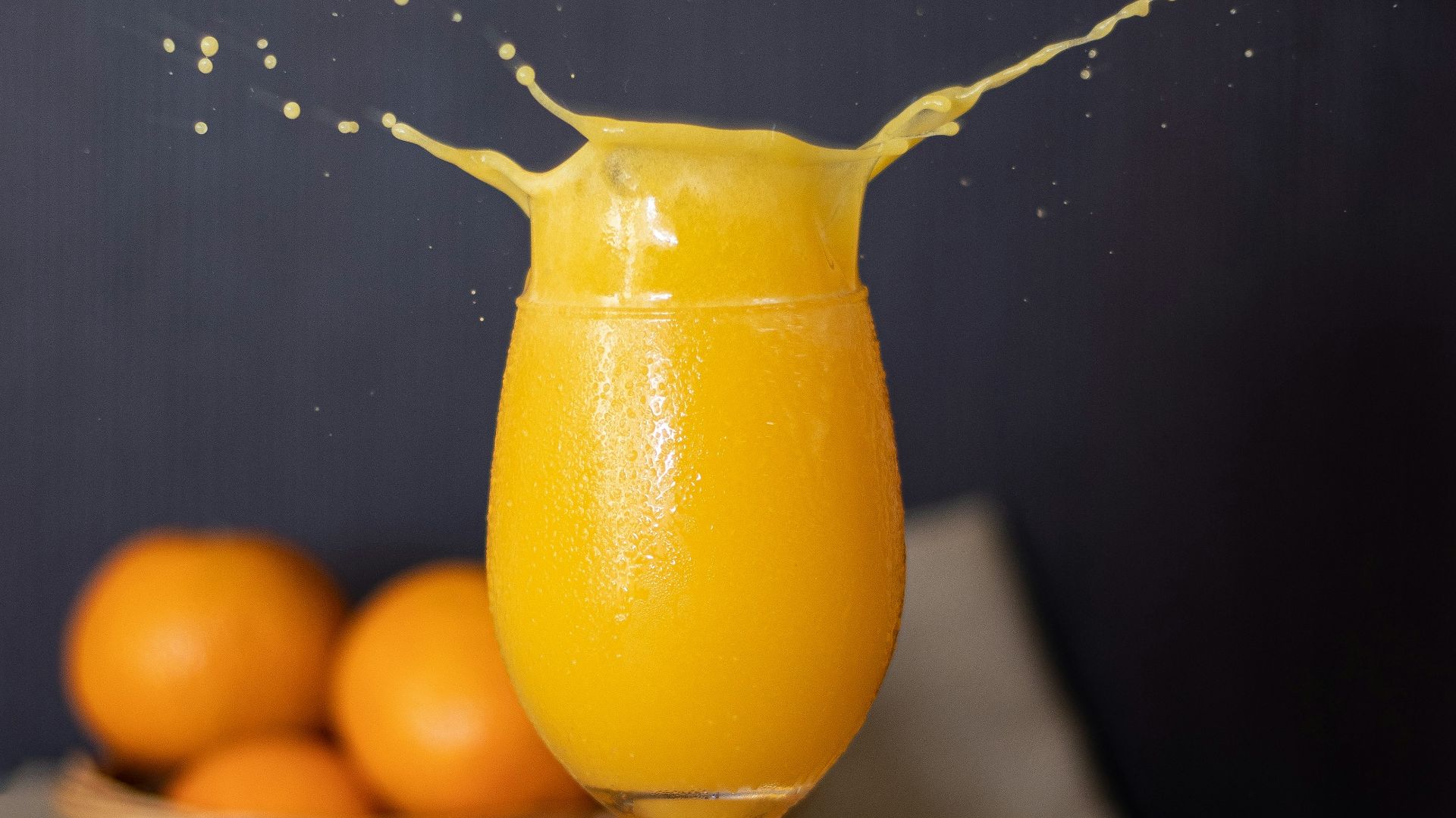 a glass of orange juice on a wooden table
