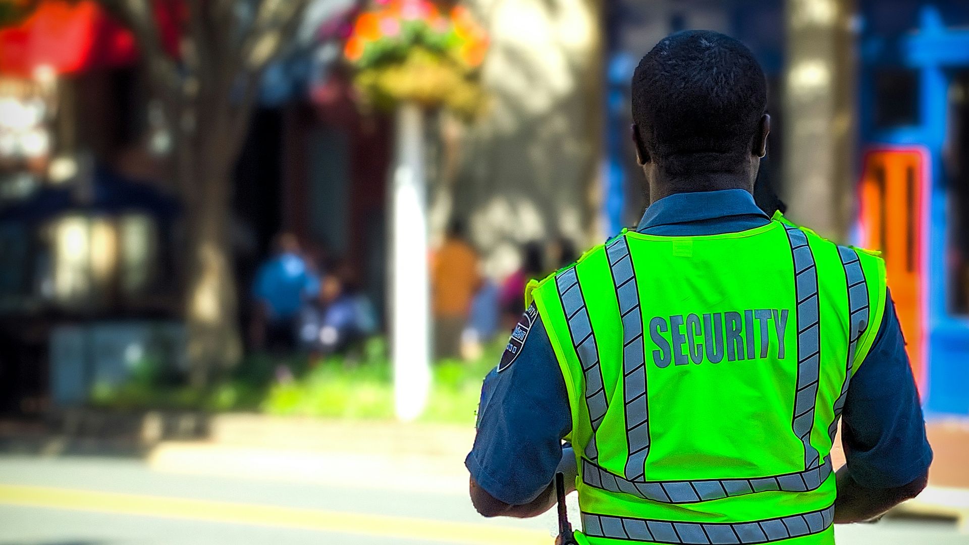 man in green and blue jacket walking on street during daytime