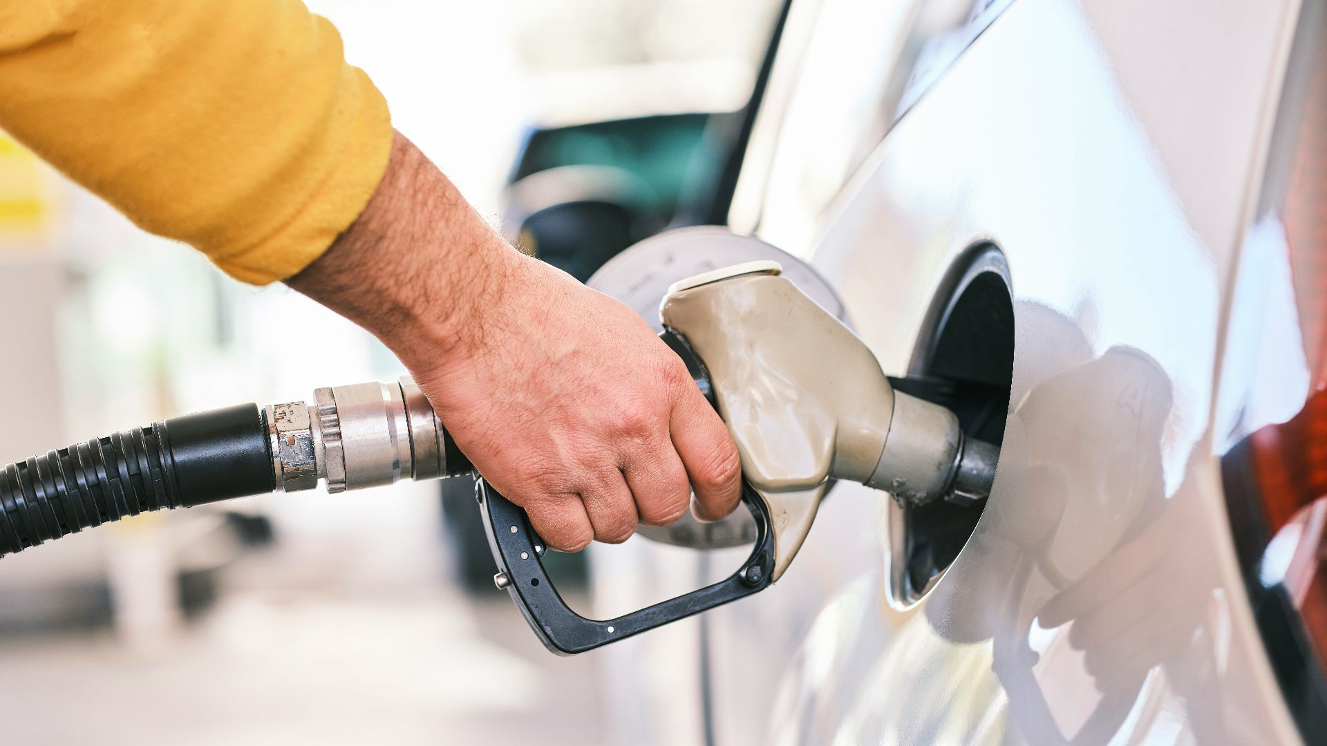 a man pumping gas into his car at a gas station