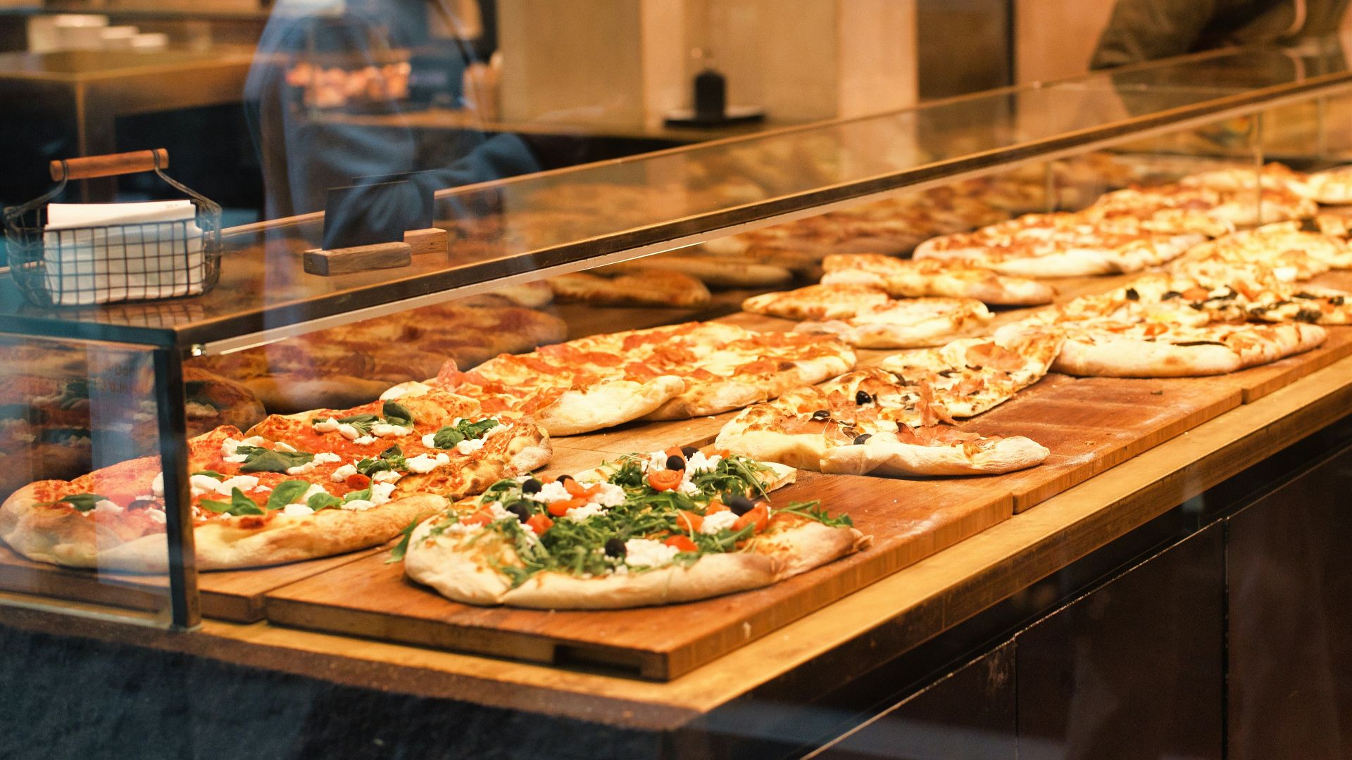 a display case filled with lots of pizzas