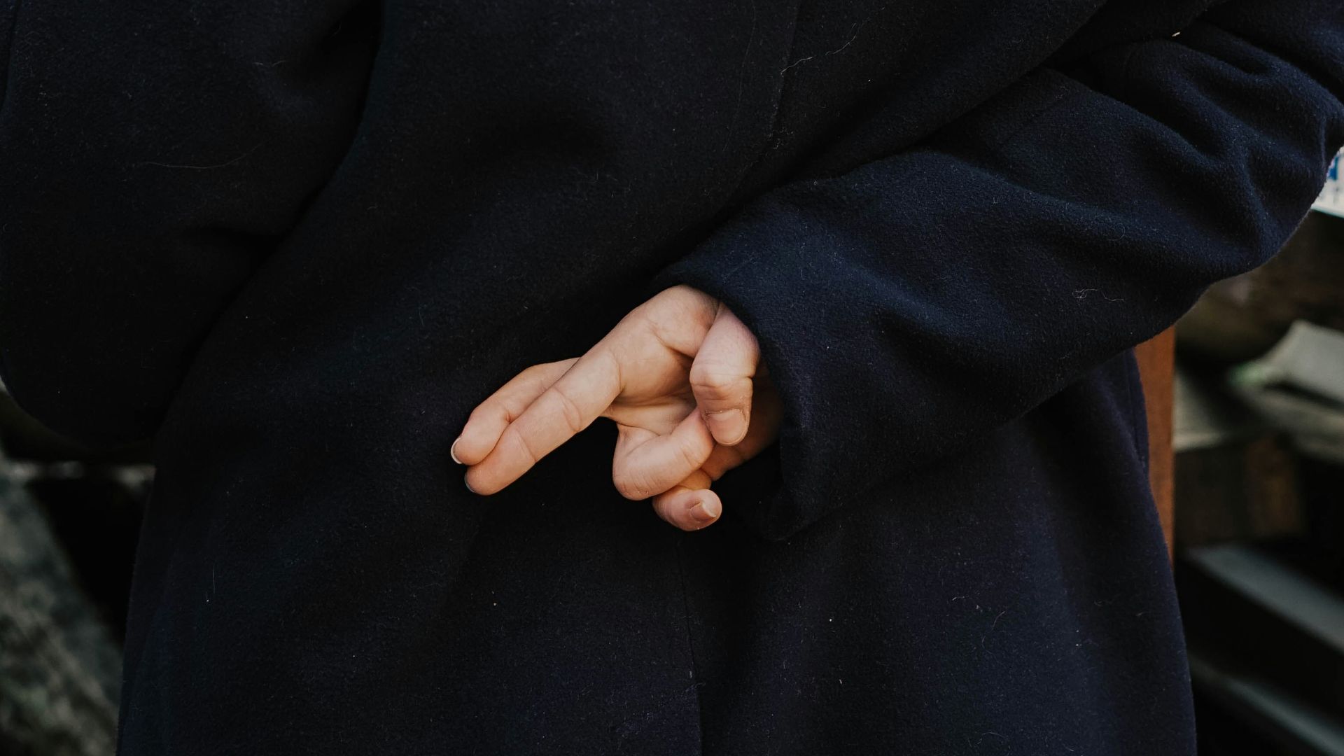 woman in blue hoodie standing in front of white and red kanji text signage