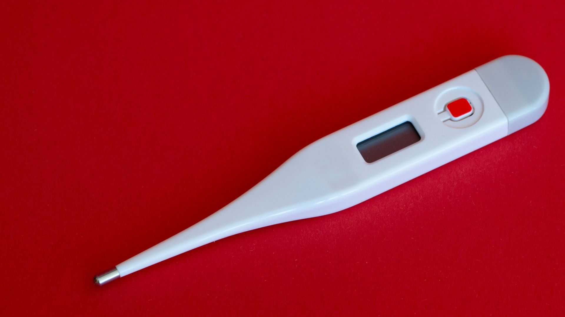 white thermometer on red surface