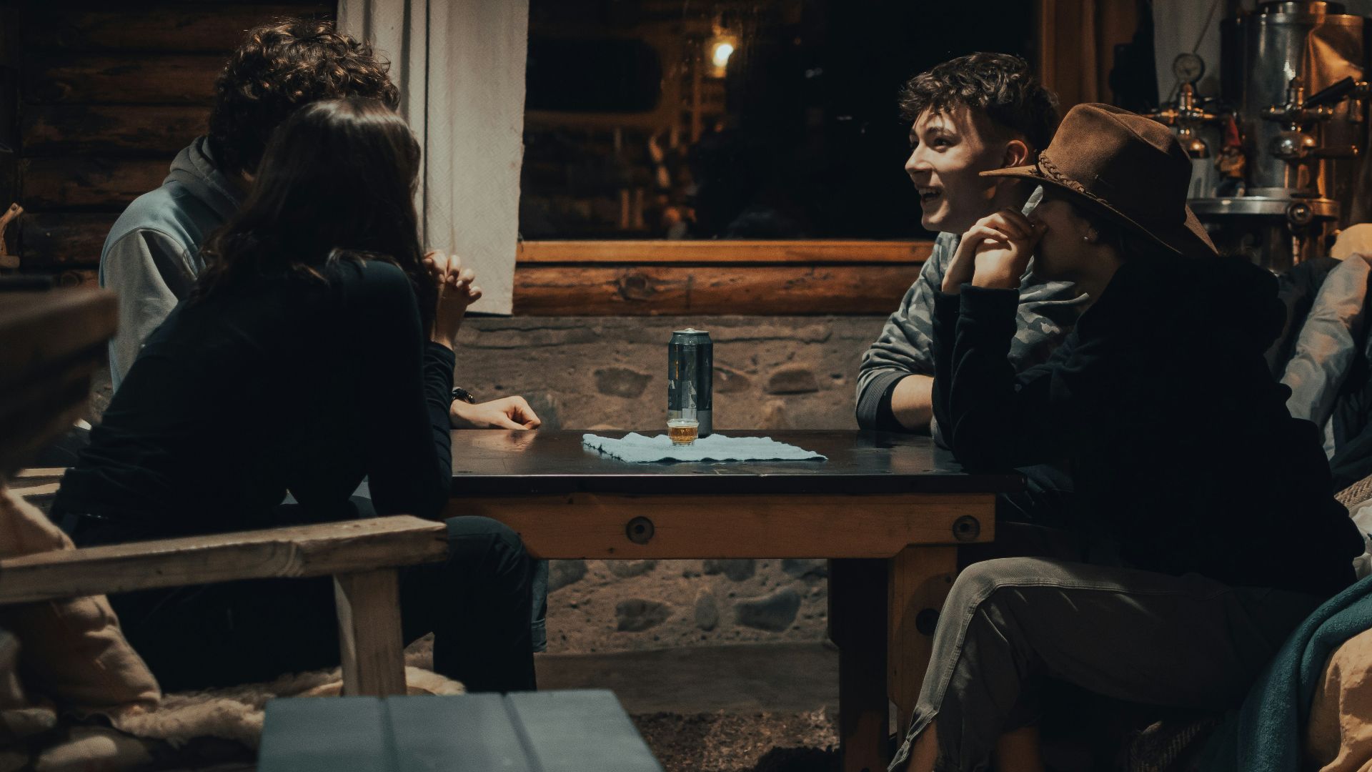 man in black jacket sitting on brown wooden chair