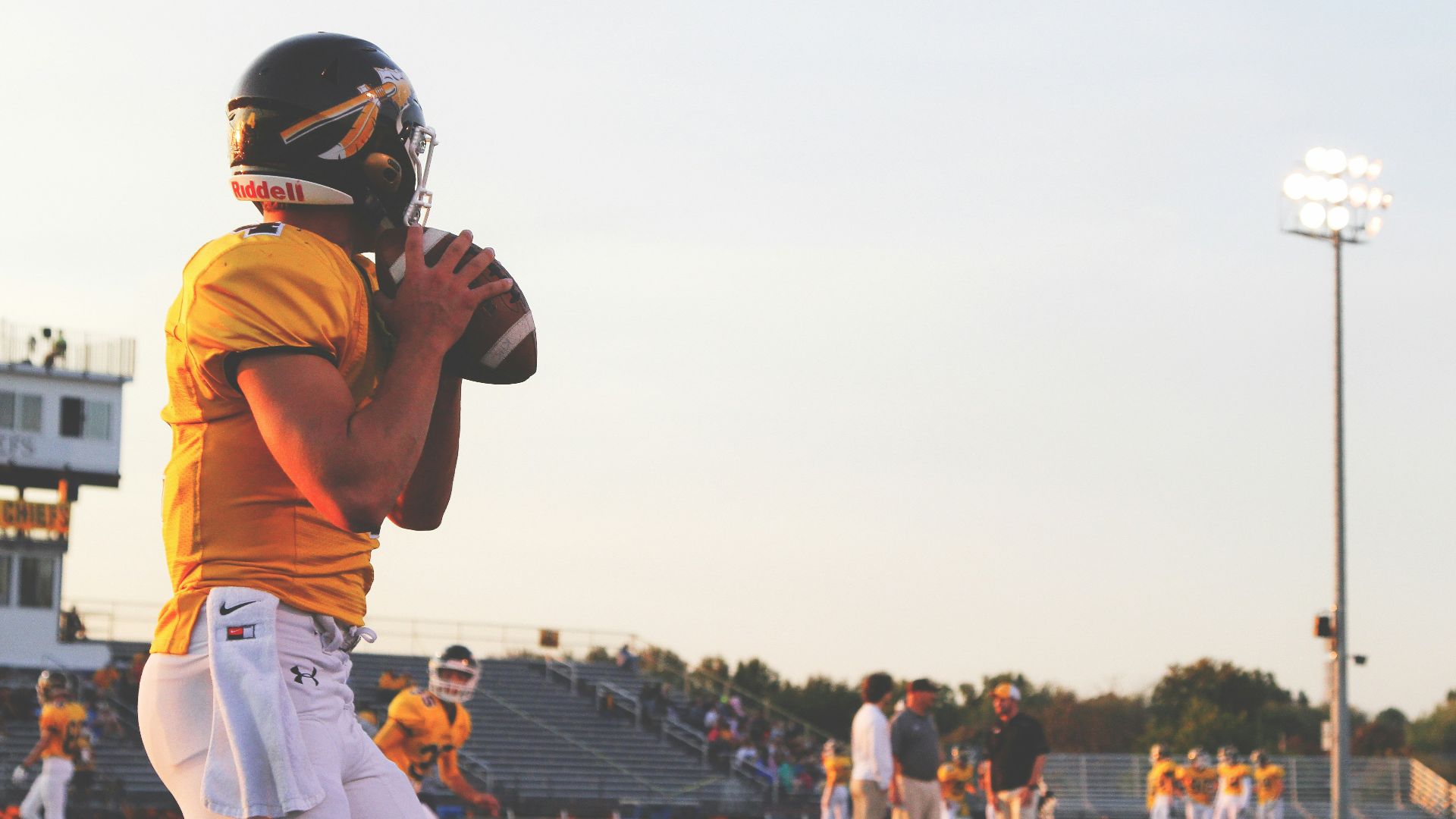 man holding brown football ball