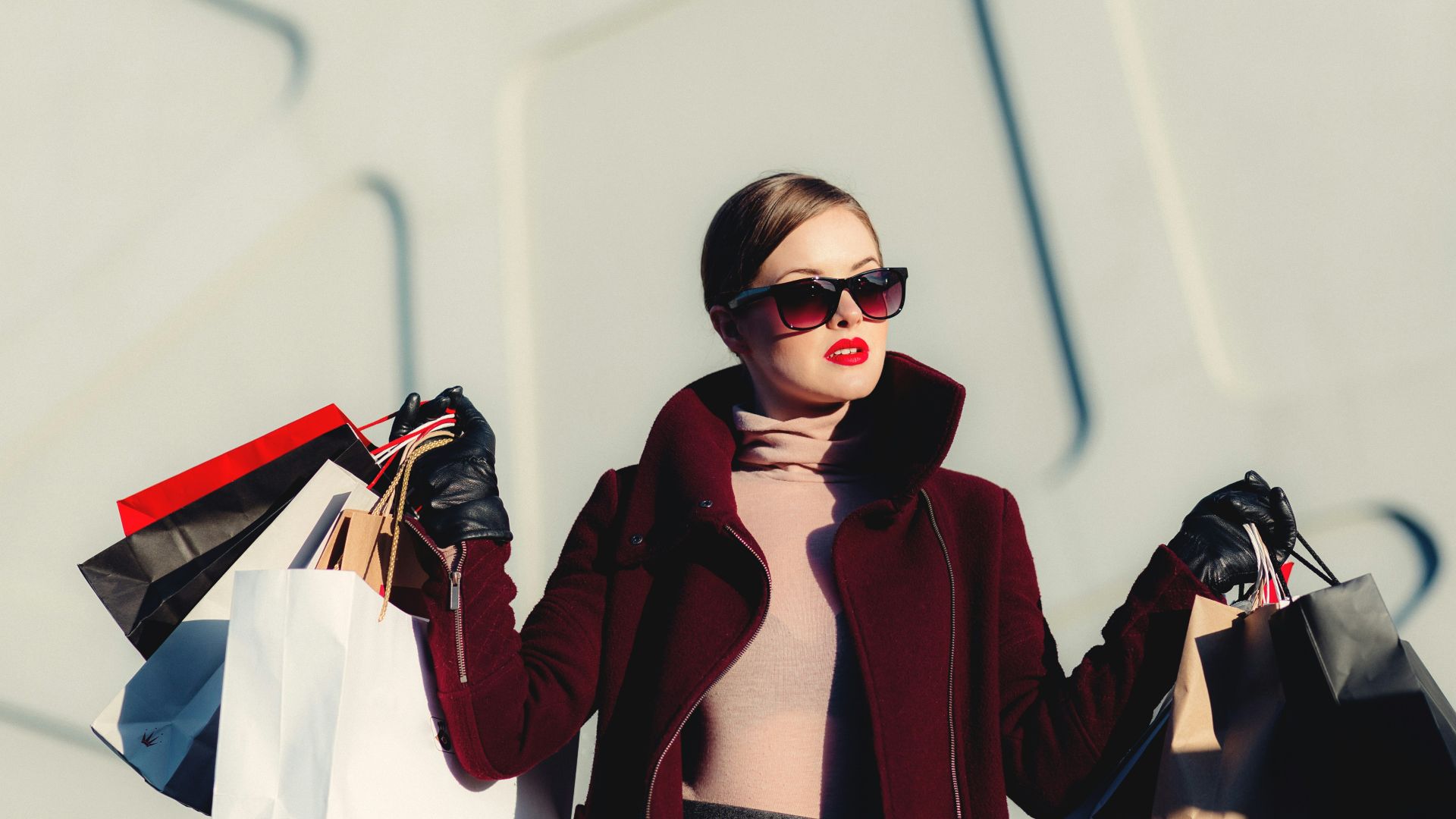 photo of woman holding white and black paper bags